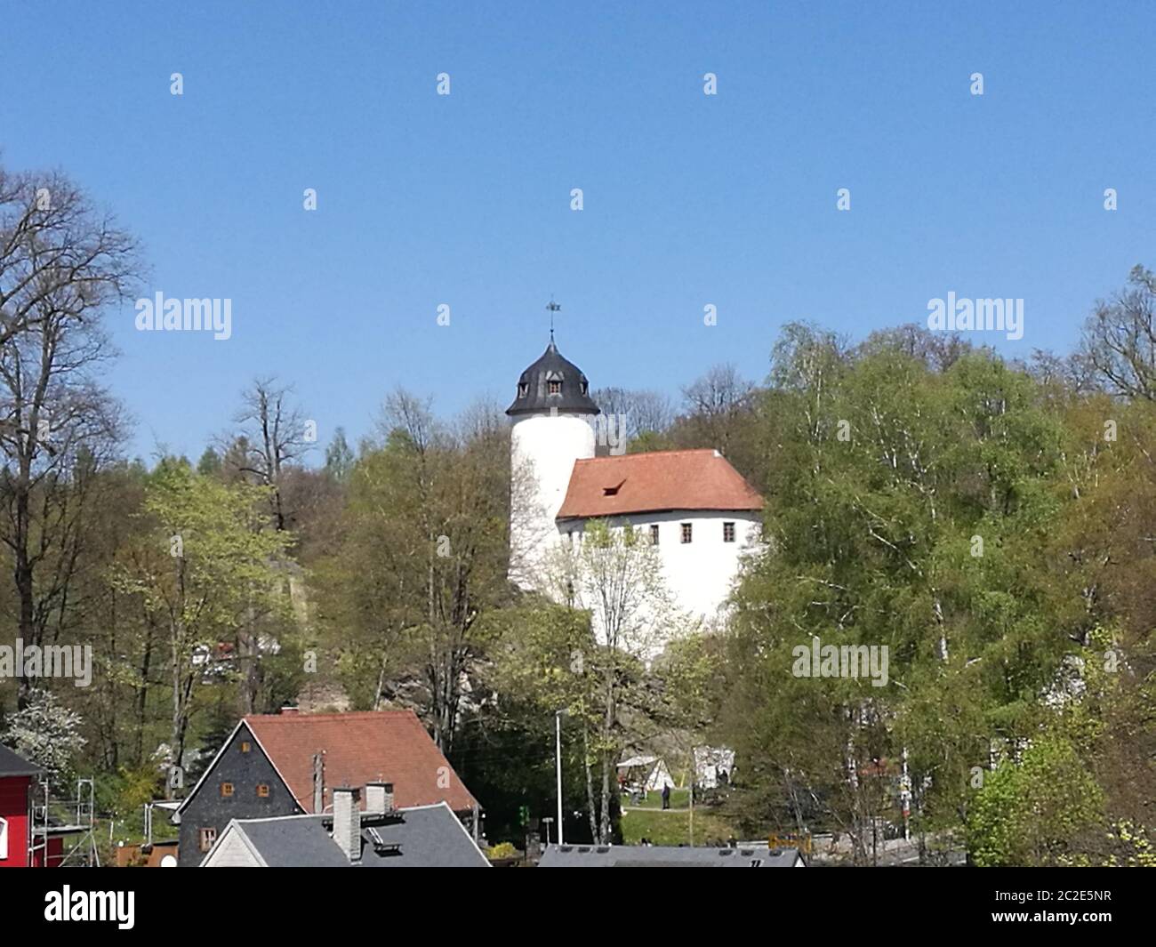 Blick über Hausdächer zur Burg Rabenstein, mittelalterliche Burganlage in Chemnitz in Sachsen, Deutschland, weiße Burganlage mit rotem Dach und einem Banque D'Images