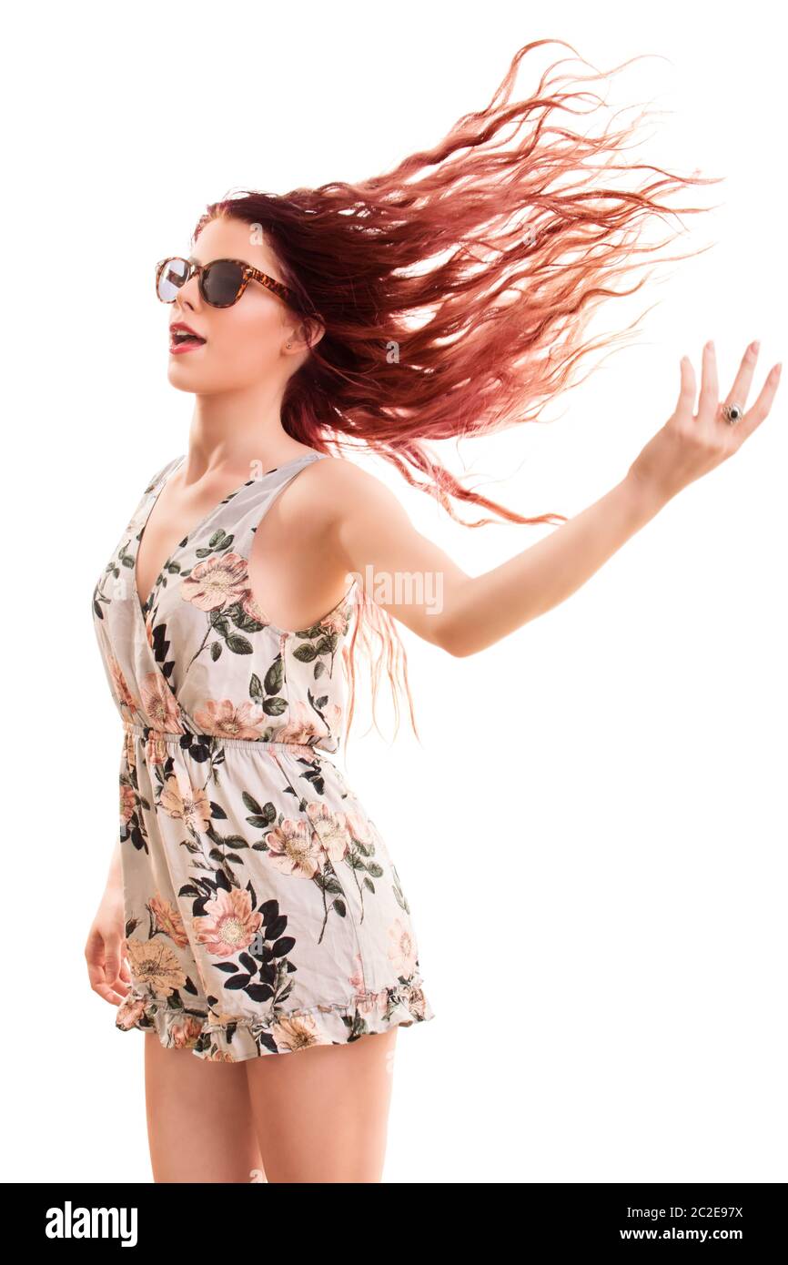 Portrait d'une belle jeune fille portant des lunettes de soleil, sauter et jouer avec ses cheveux, isolé sur fond blanc. Banque D'Images