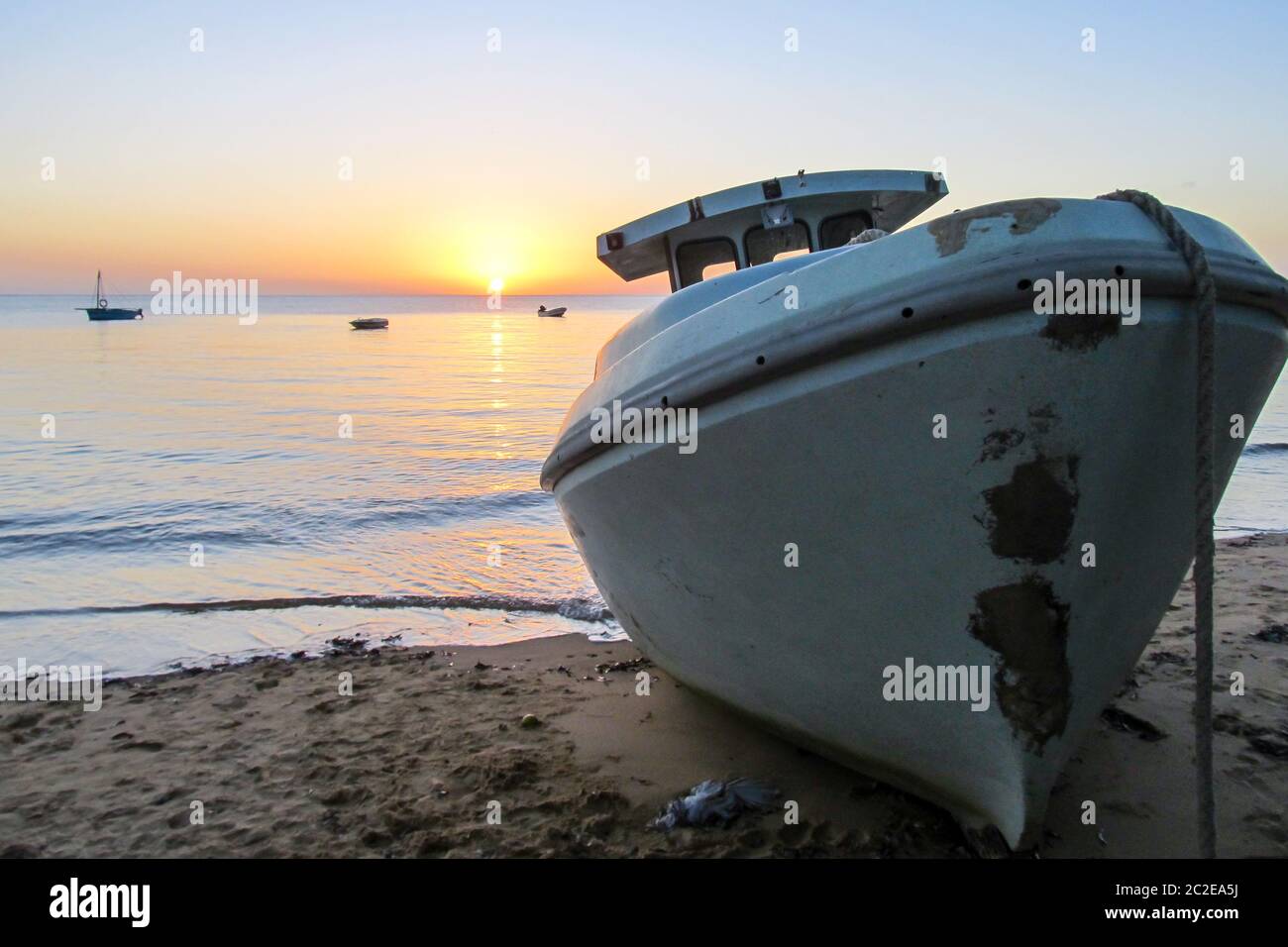 Un bateau à pêche, avec la baie de Maputo tranquille et abritée pendant le crépuscule en arrière-plan au crépuscule, vu de l'île d'Inhaca, au Mozambique Banque D'Images