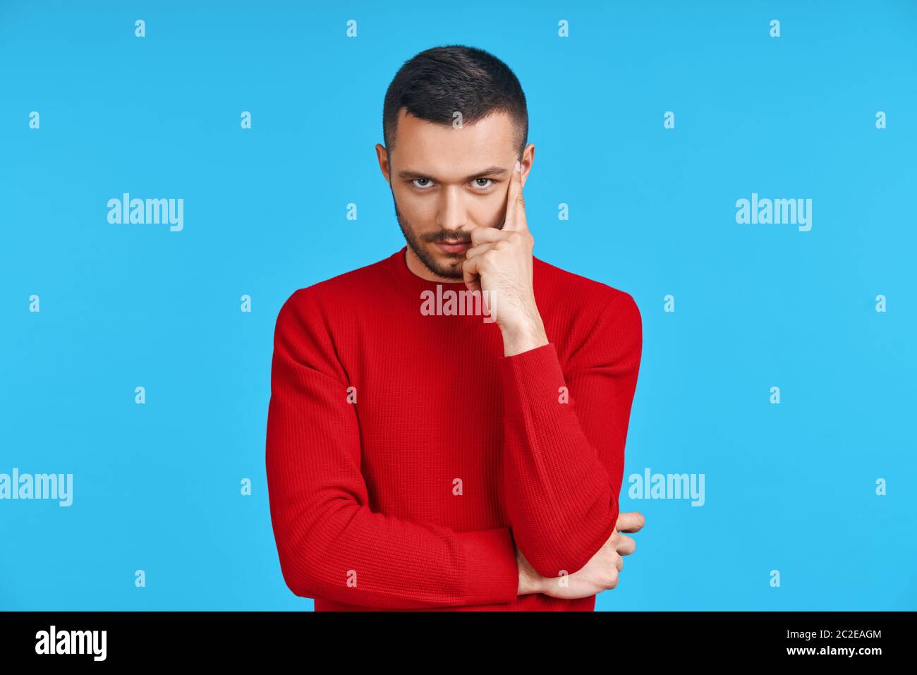 Jeune homme réfléchi pensant et regardant à l'appareil photo avec espace de copie, isolé sur fond bleu Banque D'Images