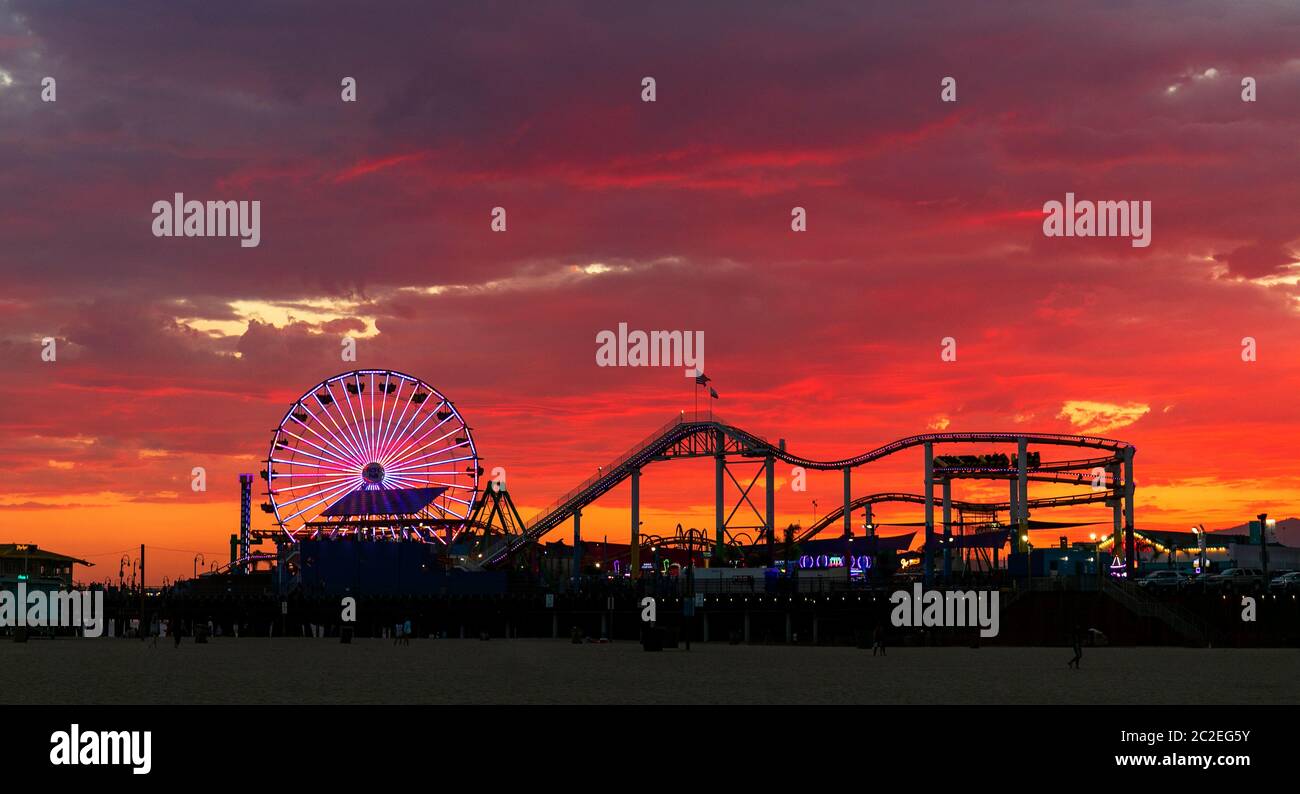 Parc d'attractions Pacific Park sur la jetée de Santa Monica sous un ciel flamboyant en raison du coucher de soleil coloré. Banque D'Images