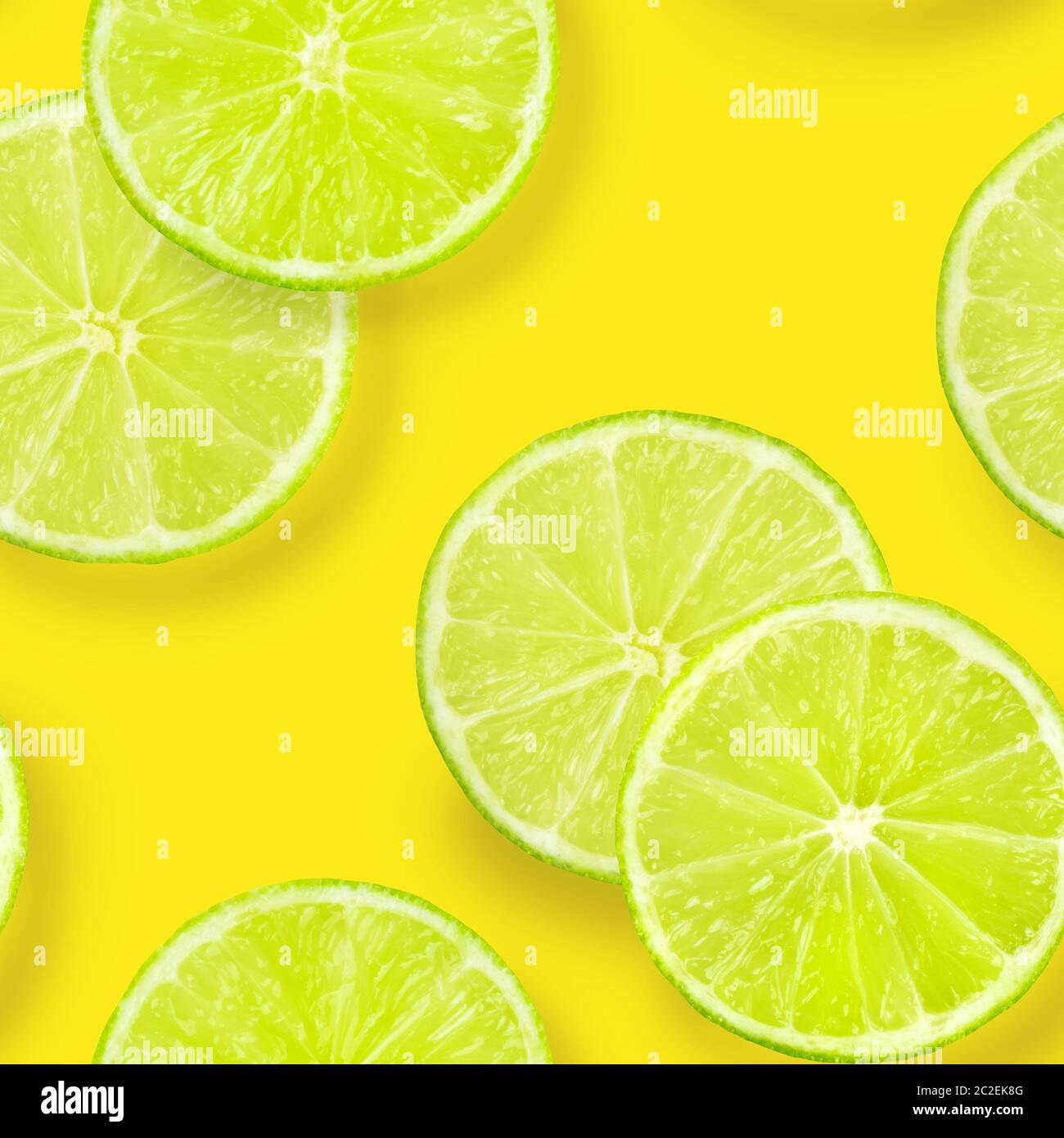 Un modèle uniforme de tranches de lime sur un fond jaune vif, une impression de répétition d'agrumes fruité Banque D'Images