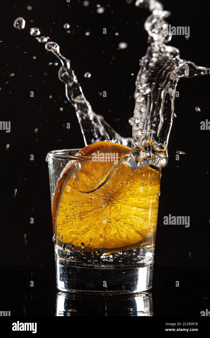 Verre, orange et éclaboussures d'eau Banque D'Images