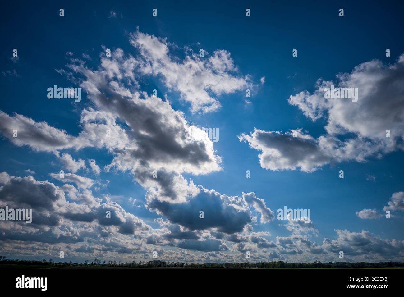 les nuages couvrent un ciel bleu et sont éclairés par le soleil. Banque D'Images