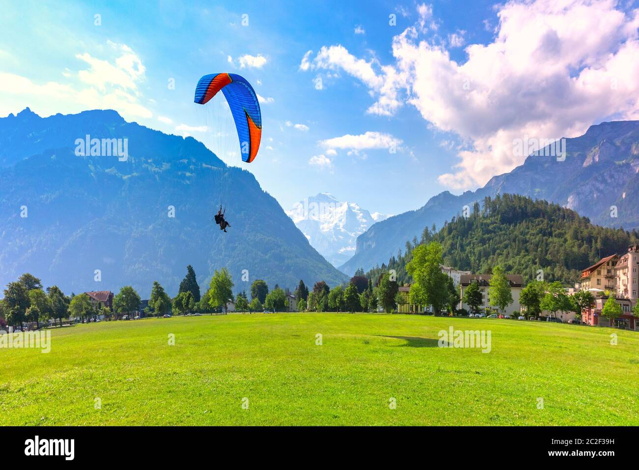 Un parapente volant au parc Hohematte dans le centre d'Interlaken, important centre touristique dans les Highlands bernois, Suisse. La Jungfrau est vis Banque D'Images