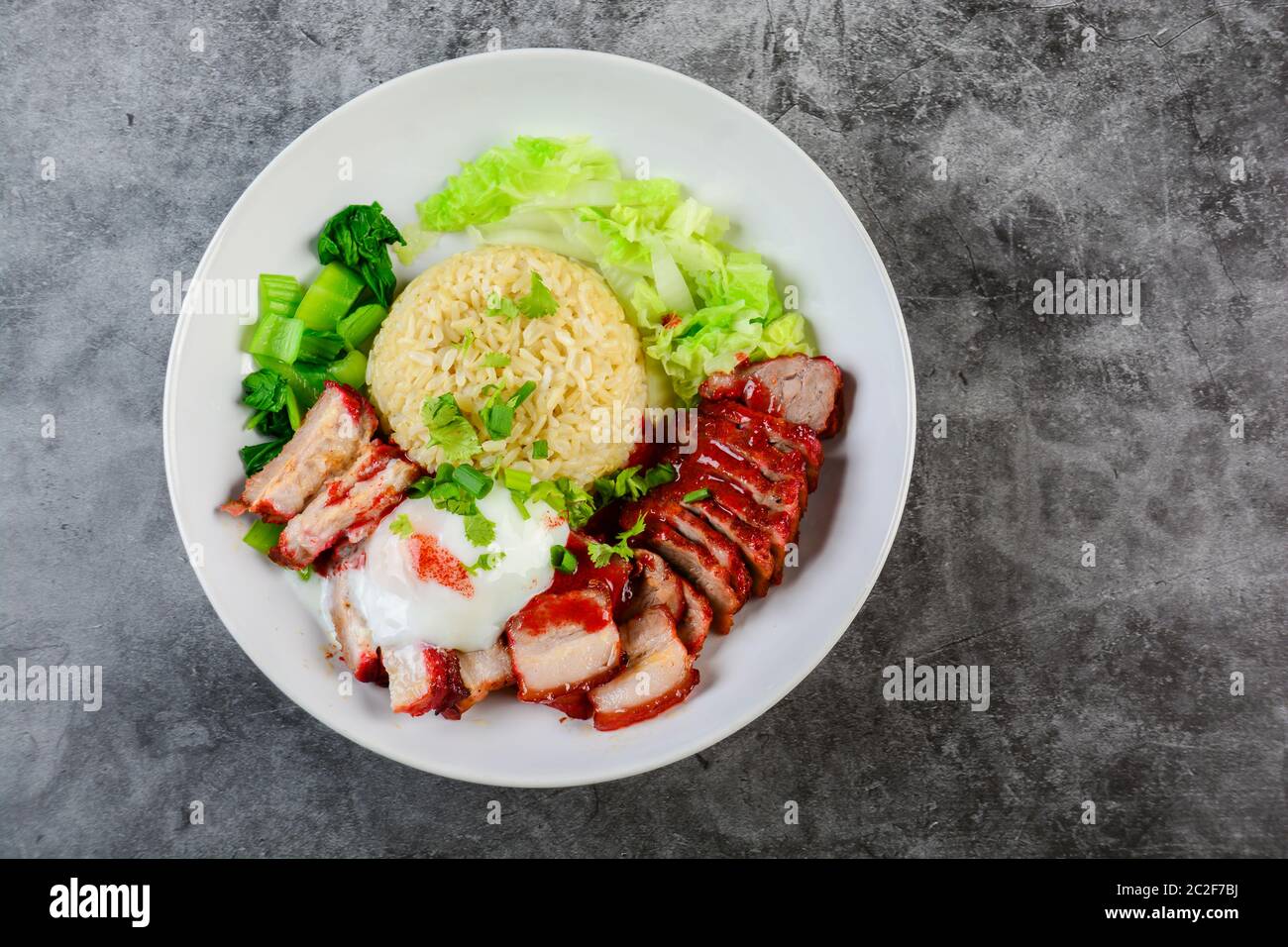 Côtelettes de porc rouge grillé en sauce rouge, servi avec du riz et légumes sur plaque blanche. Banque D'Images