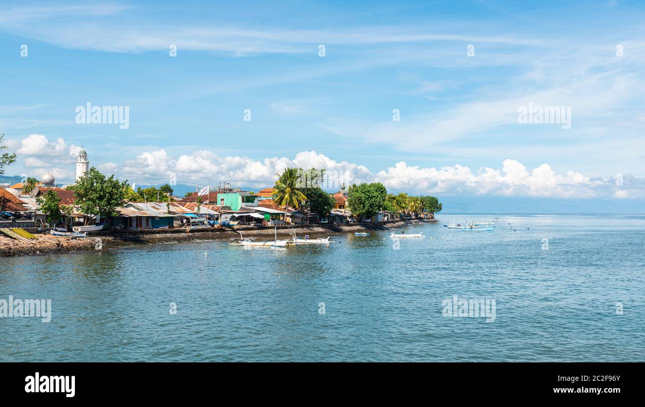 Singaraja, au nord de Bali, en Indonésie. Mosquée sur la gauche et bateaux de pêche traditionnels appelés jukung. Banque D'Images