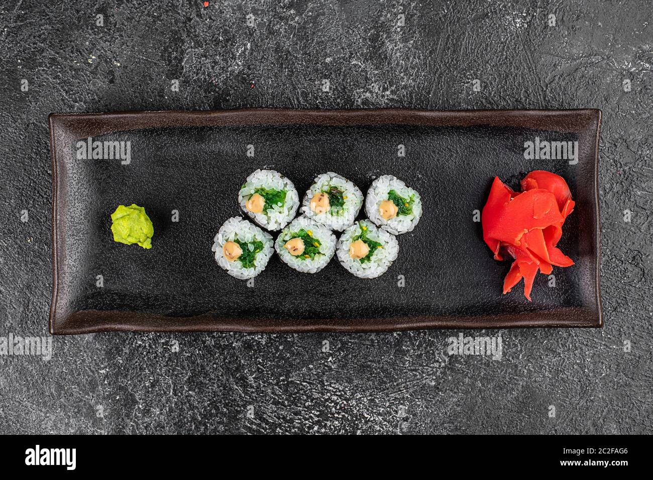 Petits pains à sushis avec fruits de mer et salade Chuka. Sushis verts. Vue de dessus. Espace libre pour votre texte. Banque D'Images