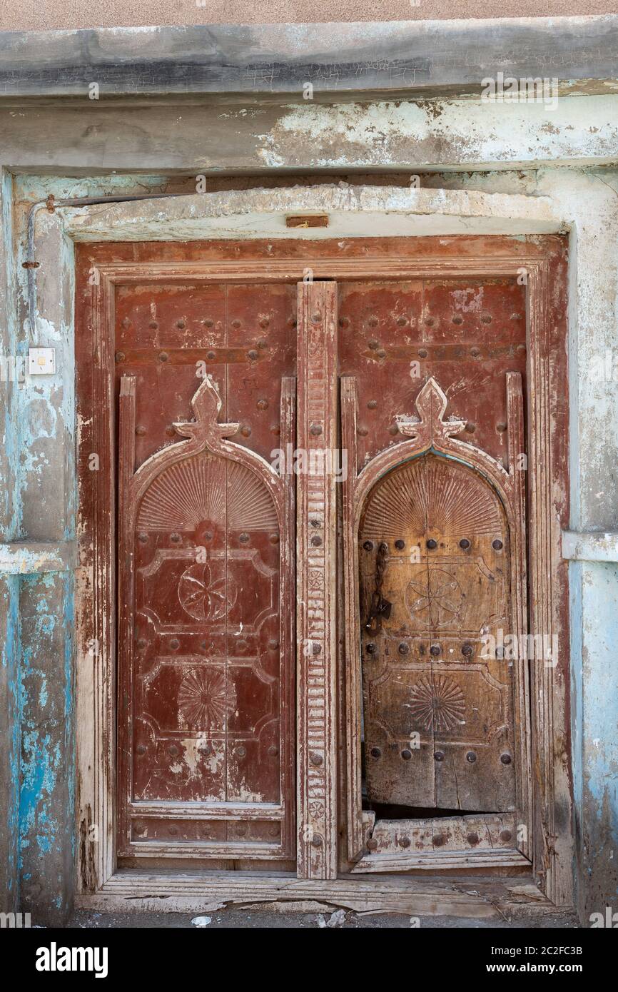 Porte traditionnelle en bois brun rougeâtre dans la ville d'Al Ayjah près de sur, Oman Banque D'Images