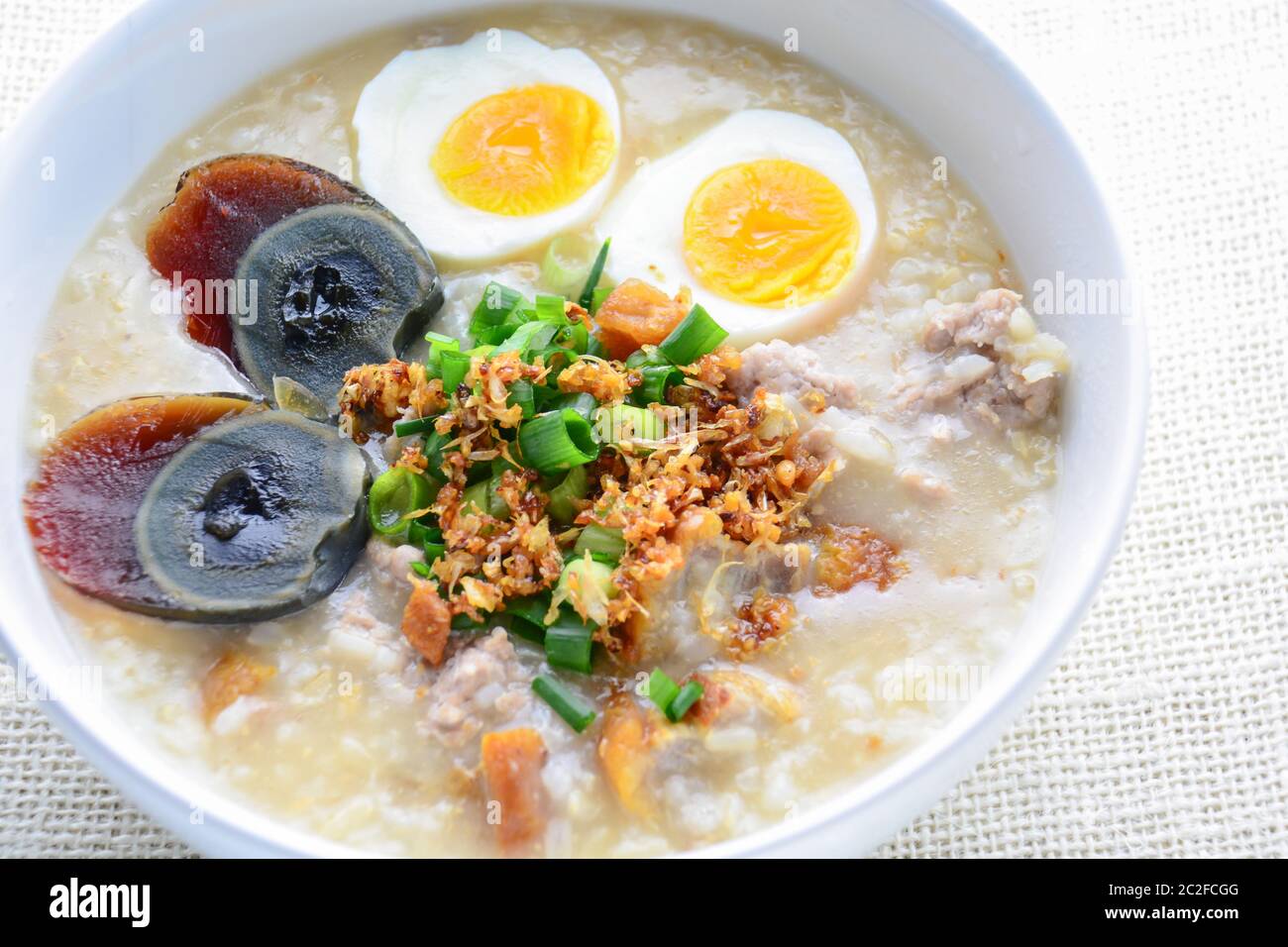 Congee, porridge de riz avec porc haché, oeuf bouilli et oeuf de siècle, super pour le petit déjeuner. Banque D'Images