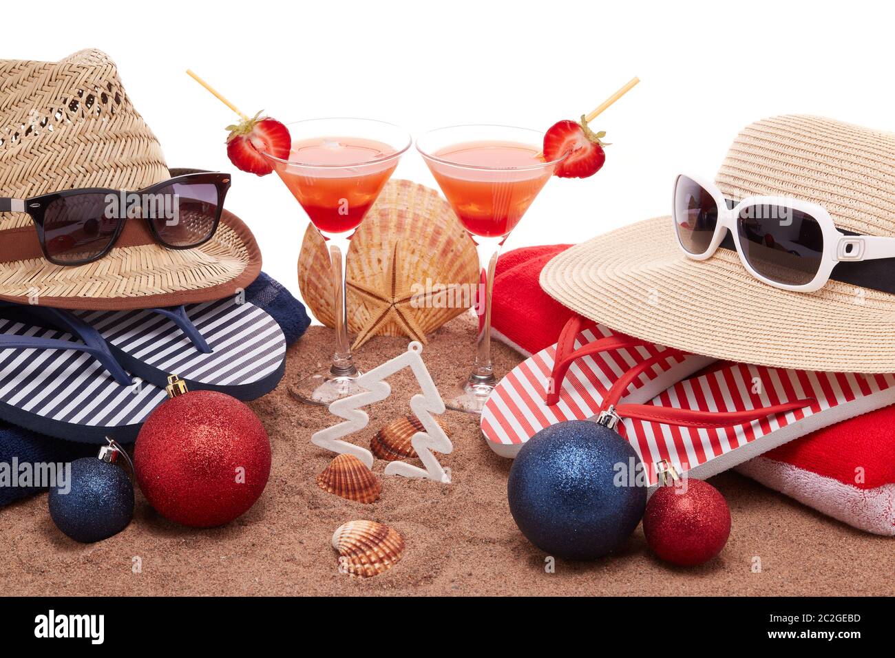 Accessoires de plage (tongs, chapeaux de paille, coquillages, sable,  lunettes de soleil), deux verres de cocktail, décorations de noël sur fond  blanc. Noël Photo Stock - Alamy