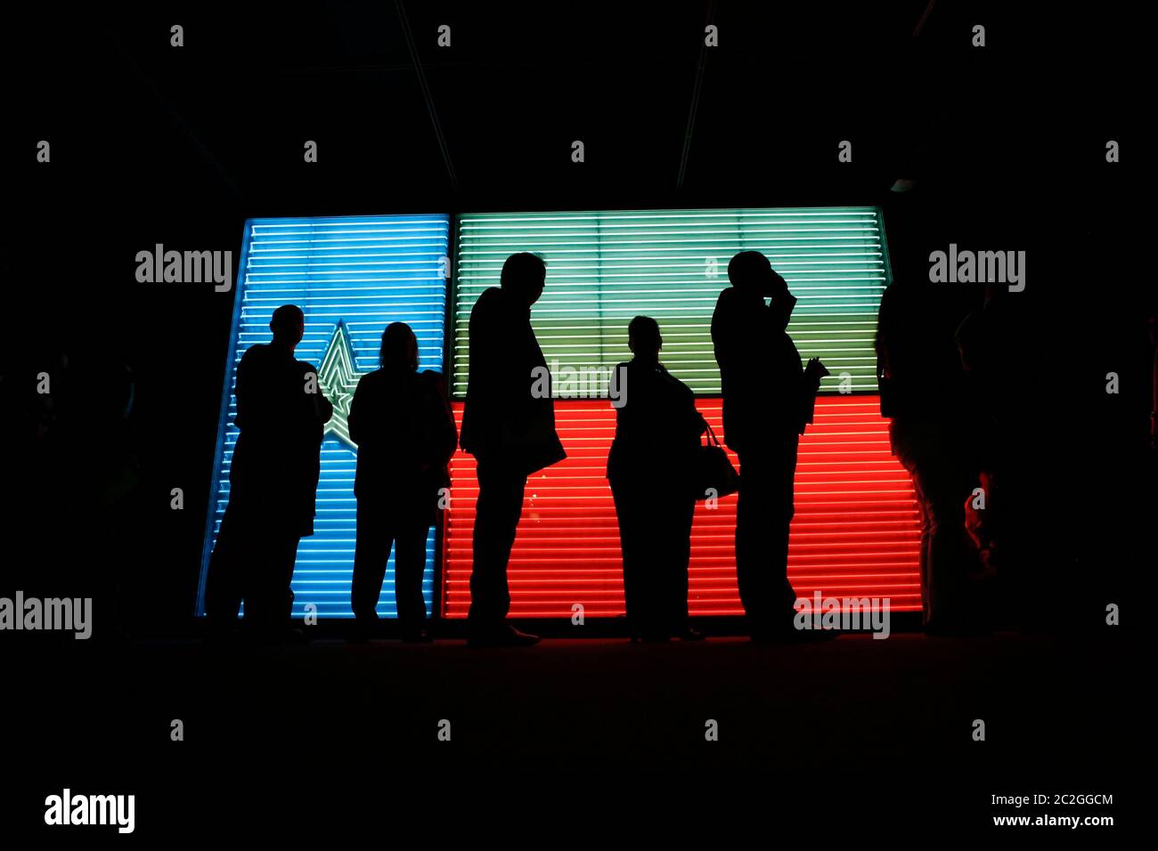 San Antonio Texas Etats-Unis, 25 mars 2016: Les gens qui se tiennent en ligne à l'Institut des cultures texanes sont silhouettés contre un grand fluo rendu d'un drapeau du Texas. ©Bob Daemmrich Banque D'Images