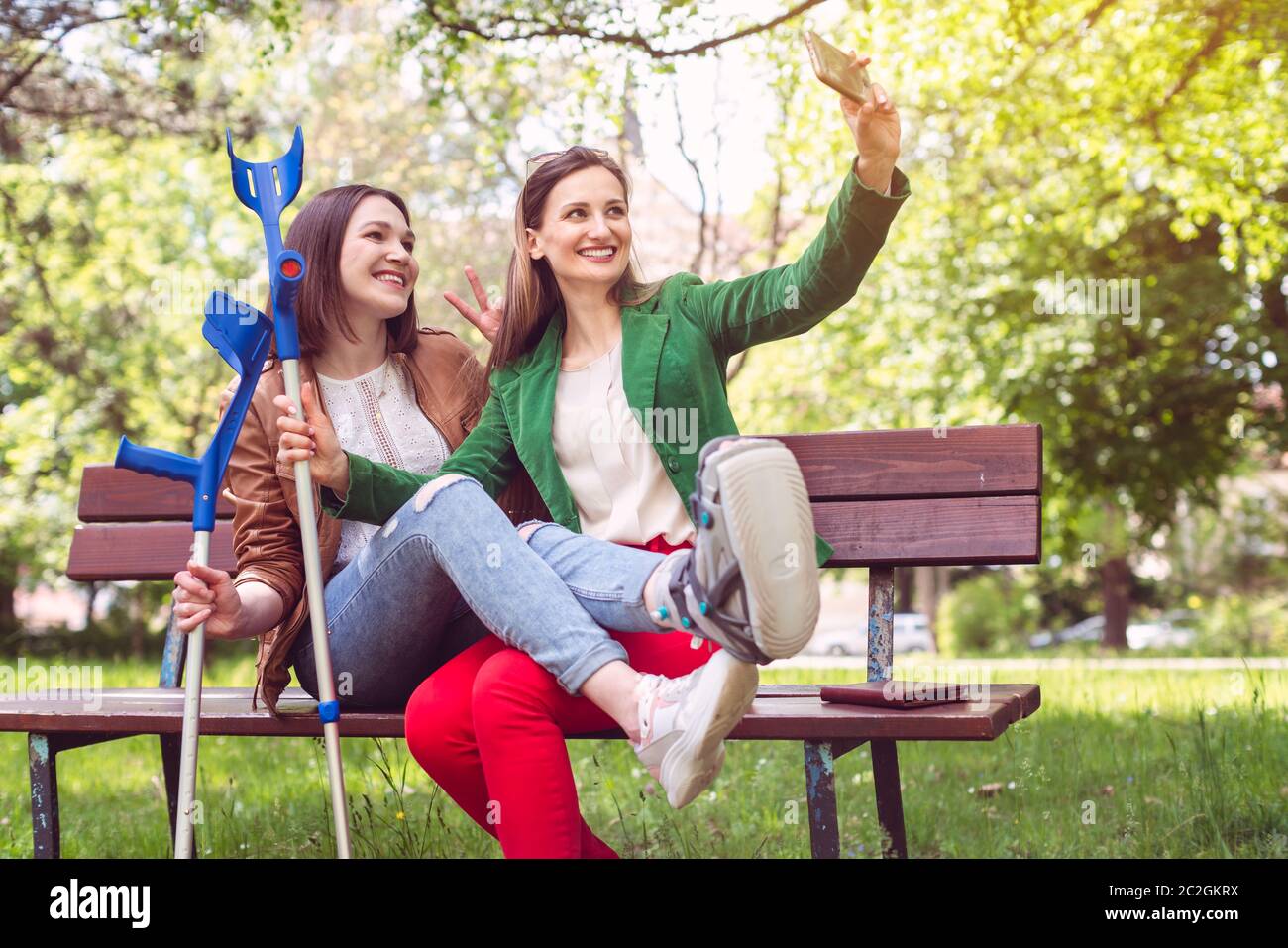 Meilleurs amis avec un ayant une jambe cassée prenant un selfie au téléphone Banque D'Images