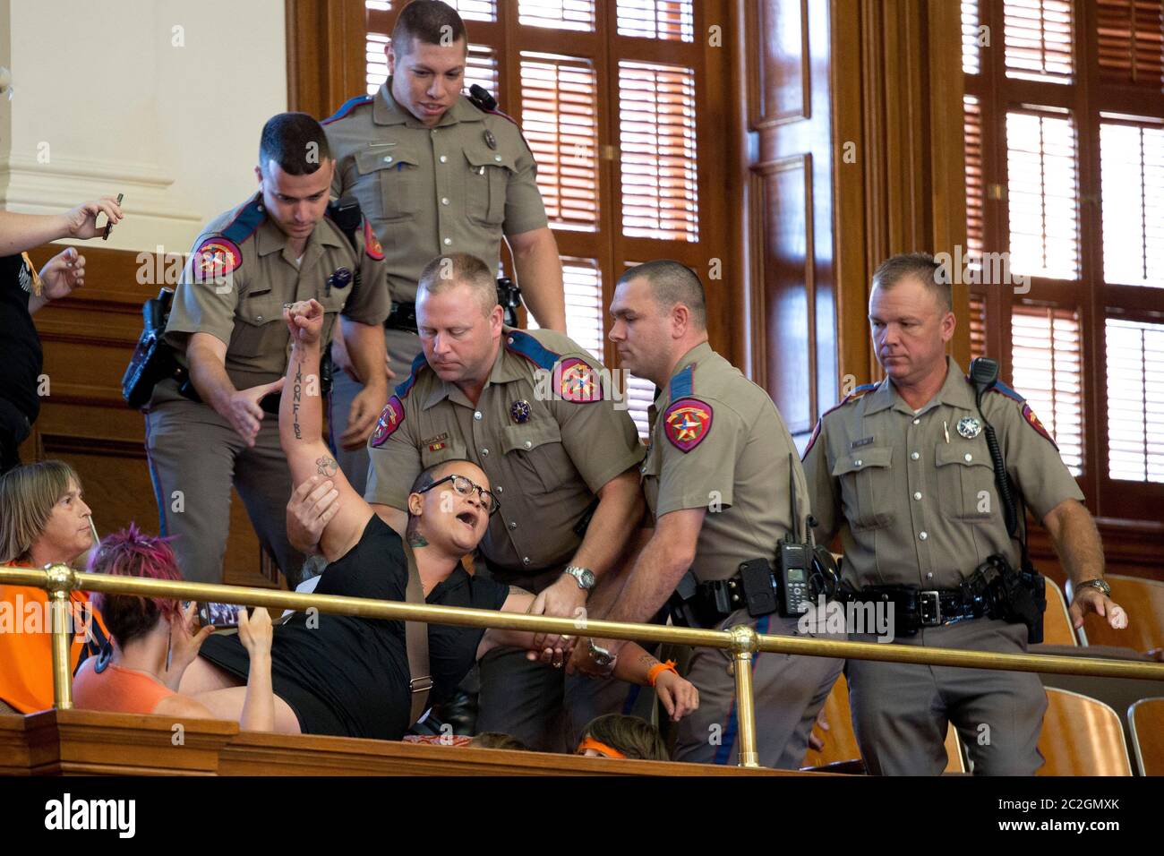 Austin Texas USA, juillet 2013: Un manifestant est tiré de la galerie publique par le Département du Texas des troopeurs de sécurité publique après un vote final de la Chambre sur un projet de loi HB2 qui limite davantage les prestataires d'avortement au Texas. La femme a violé une règle de la Chambre interdisant les manifestations à l'intérieur de la Chambre. Les défenseurs de Pro-Life et de Pro-Choice ont inondé le Capitole du Texas de marches et de manifestations au cours des deux dernières semaines. ©Bob Daemmrich Banque D'Images