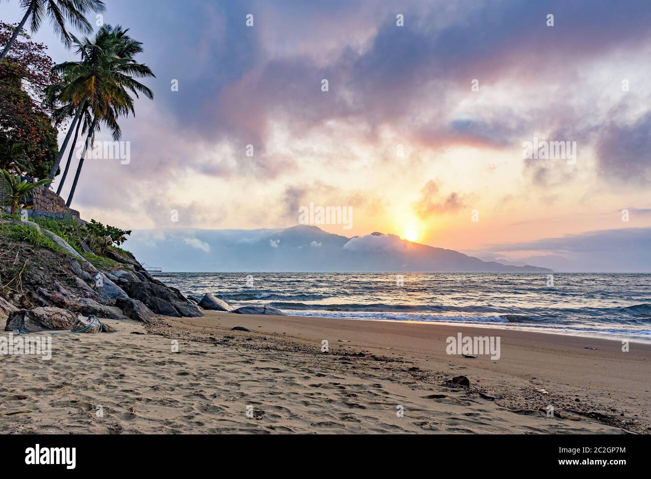 Coucher de soleil derrière les montagnes sur une plage sur l'île d'Ilhabela Banque D'Images