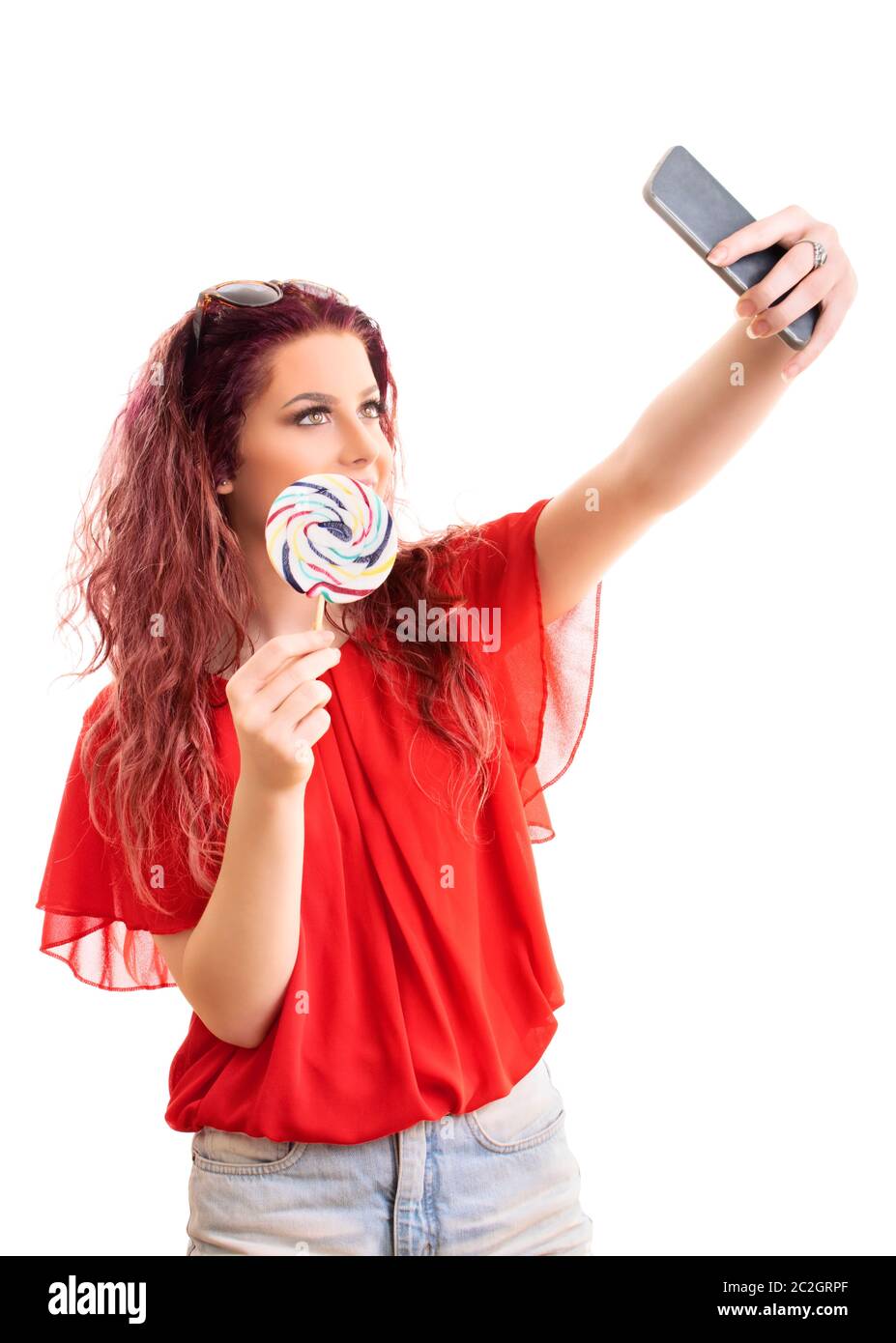 Belle jeune fille à la mode de prendre un avec selfies une sucette, isolé sur fond blanc. Banque D'Images