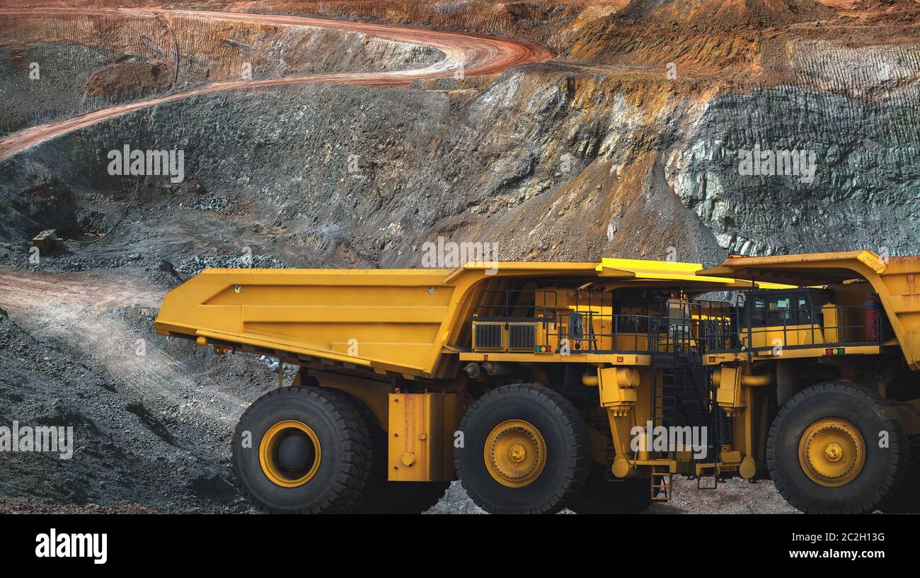 Dans la mine d'or, un grand camion jaune transportant du minerai d'or à la machine de traitement, vue panoramique Banque D'Images