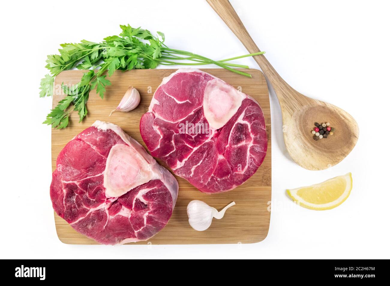 Tiges de veau d'Ossobuco avec persil, citron et ail pour une gremolata, ingrédients typiques de la cuisine italienne Lombard, plat sur un Banque D'Images