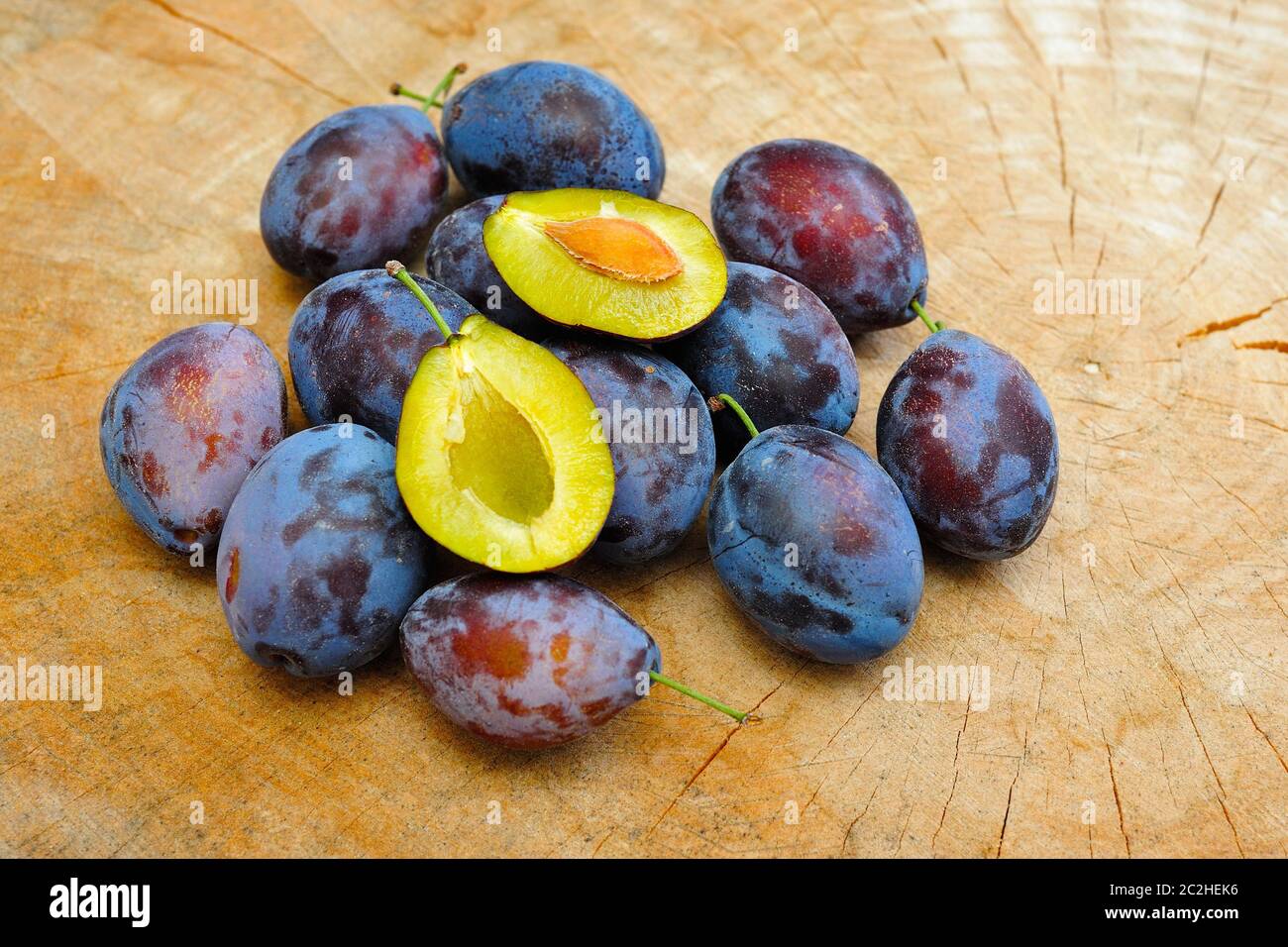 Prunes fraîches sur une assiette en bois Banque D'Images