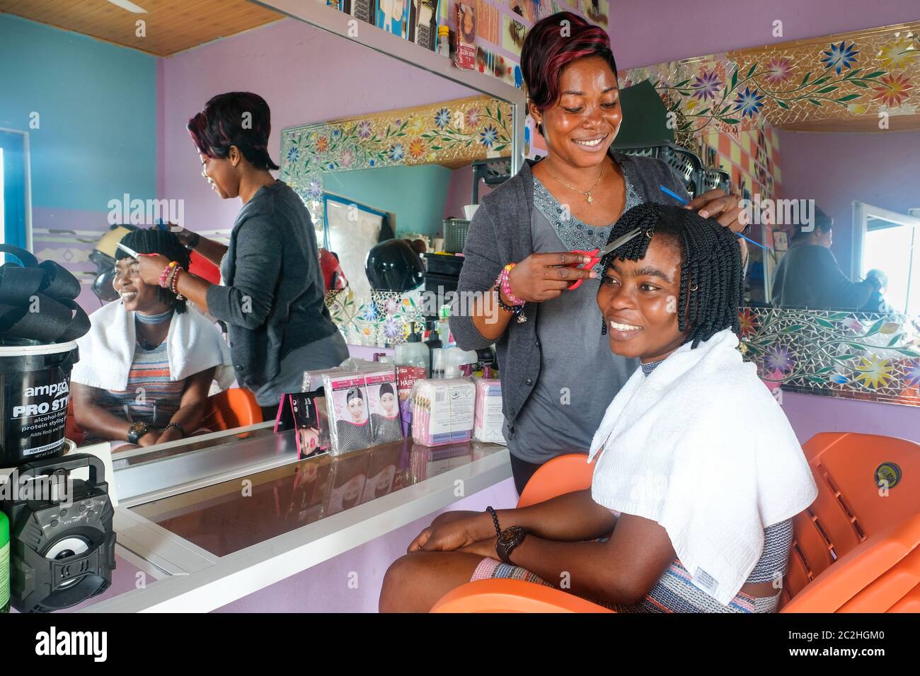 Coiffeur Naomi Boateng (35) sert une cliente dans son salon de coiffure à Tikobo au Ghana, en Afrique. Banque D'Images