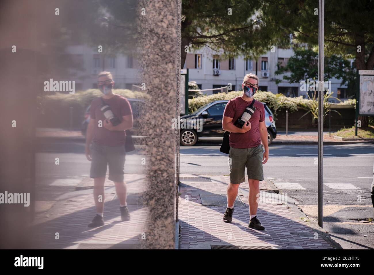 Un photographe de rue journaliste portant un masque médical selon un décret de quarantaine du coronavirus. Travailler en toute sécurité en cas de pandémie d'épidémie Covid-19. Banque D'Images