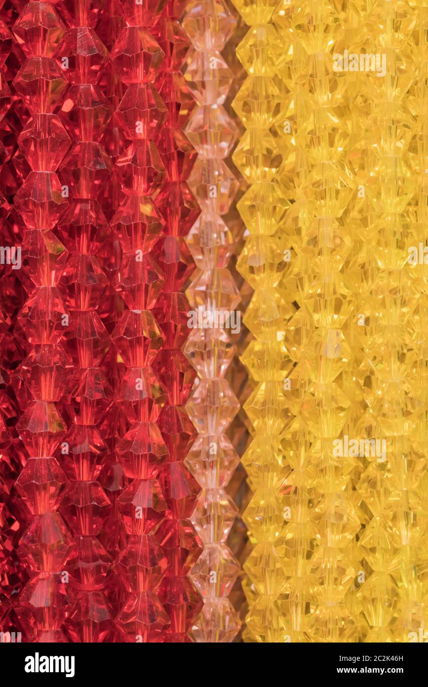 Texture découpe sur plusieurs gros plan rouge et jaune transparent en forme de diamant collier de perle. Banque D'Images