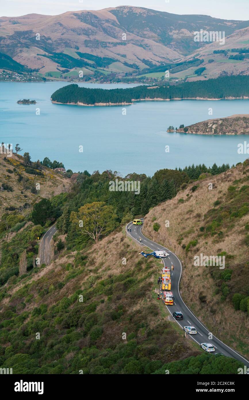 Un hélicoptère de secours est stationné sur la route tandis que les services d'urgence travaillent pour libérer le conducteur d'un véhicule qui a quitté la route sur une colline à Christchurch Banque D'Images Un hélicoptère de secours est stationné sur la route tandis que les services d'urgence travaillent pour libérer le conducteur d'un véhicule qui a quitté la route sur une colline à Christchurch Banque D'Images