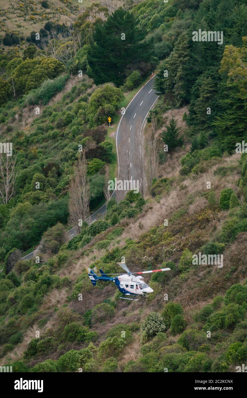 Un hélicoptère de sauvetage BK117 / H145 récupère le conducteur d'un véhicule qui a quitté la route et est tombé sur une pente abrupte couverte de brousse à Christchurch, en Nouvelle-Zélande Banque D'Images Un hélicoptère de sauvetage BK117 / H145 récupère le conducteur d'un véhicule qui a quitté la route et est tombé sur une pente abrupte couverte de brousse à Christchurch, en Nouvelle-Zélande Banque D'Images