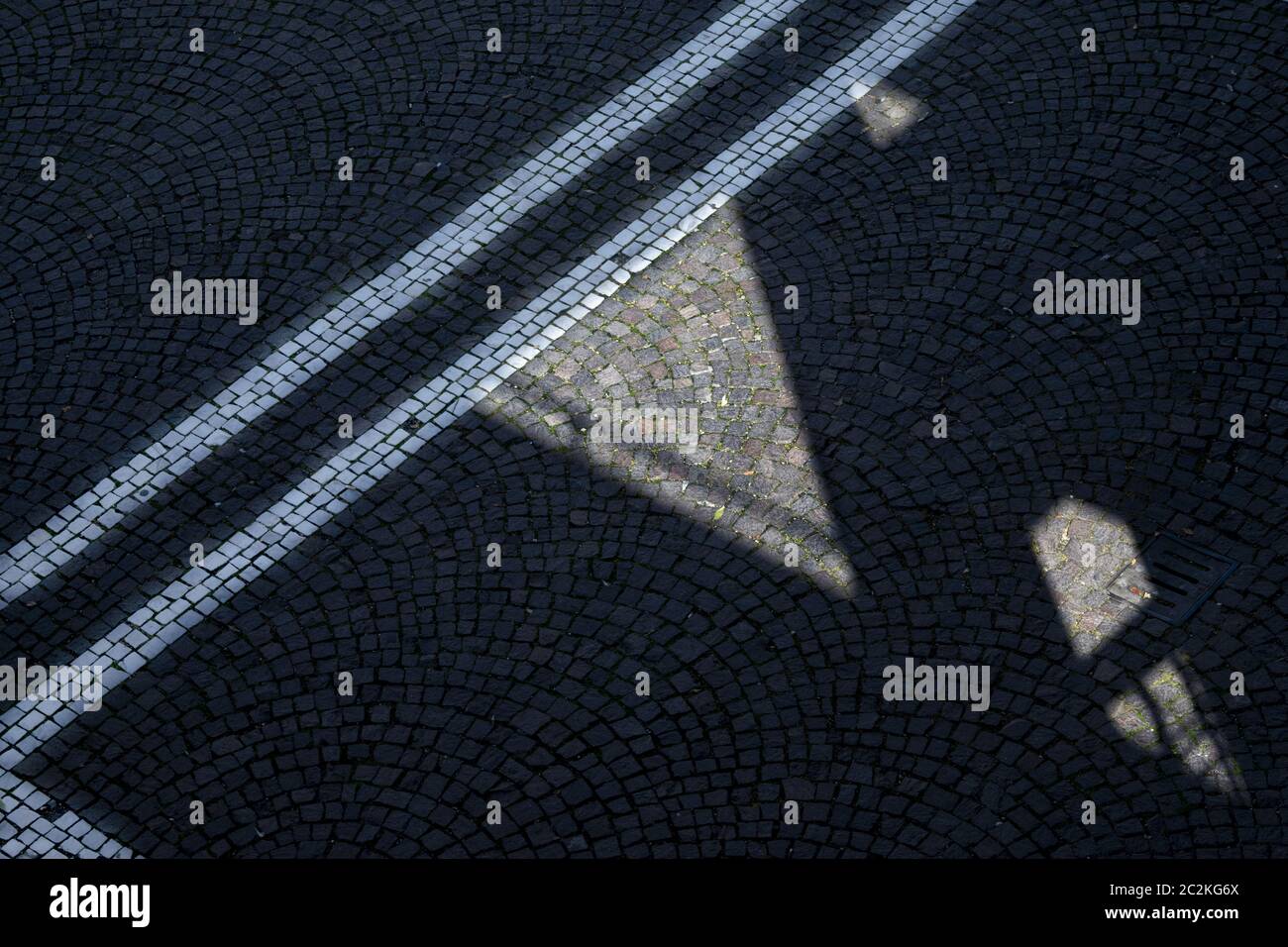 Des géométries et des lignes sur un pavé d'une rue Banque D'Images