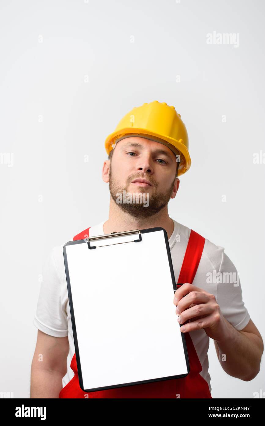 Ouvrier de la construction tenant une planchette à pince vierge avec du papier blanc, sur fond blanc Banque D'Images