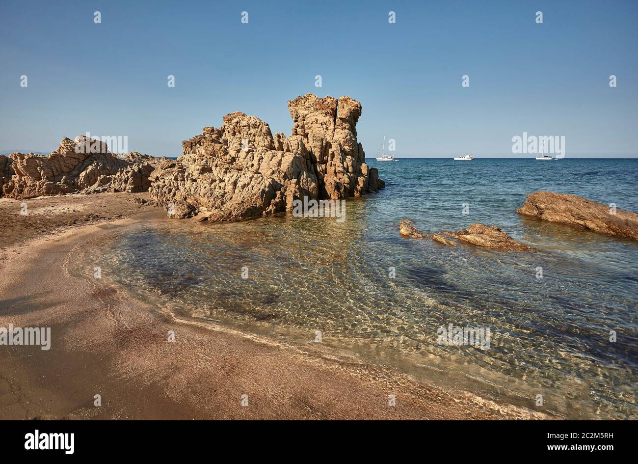 Rocky sud sardaigne plage avec des vagues de mer transparente à venir à terre pour fusionner avec Golden Beach. Banque D'Images