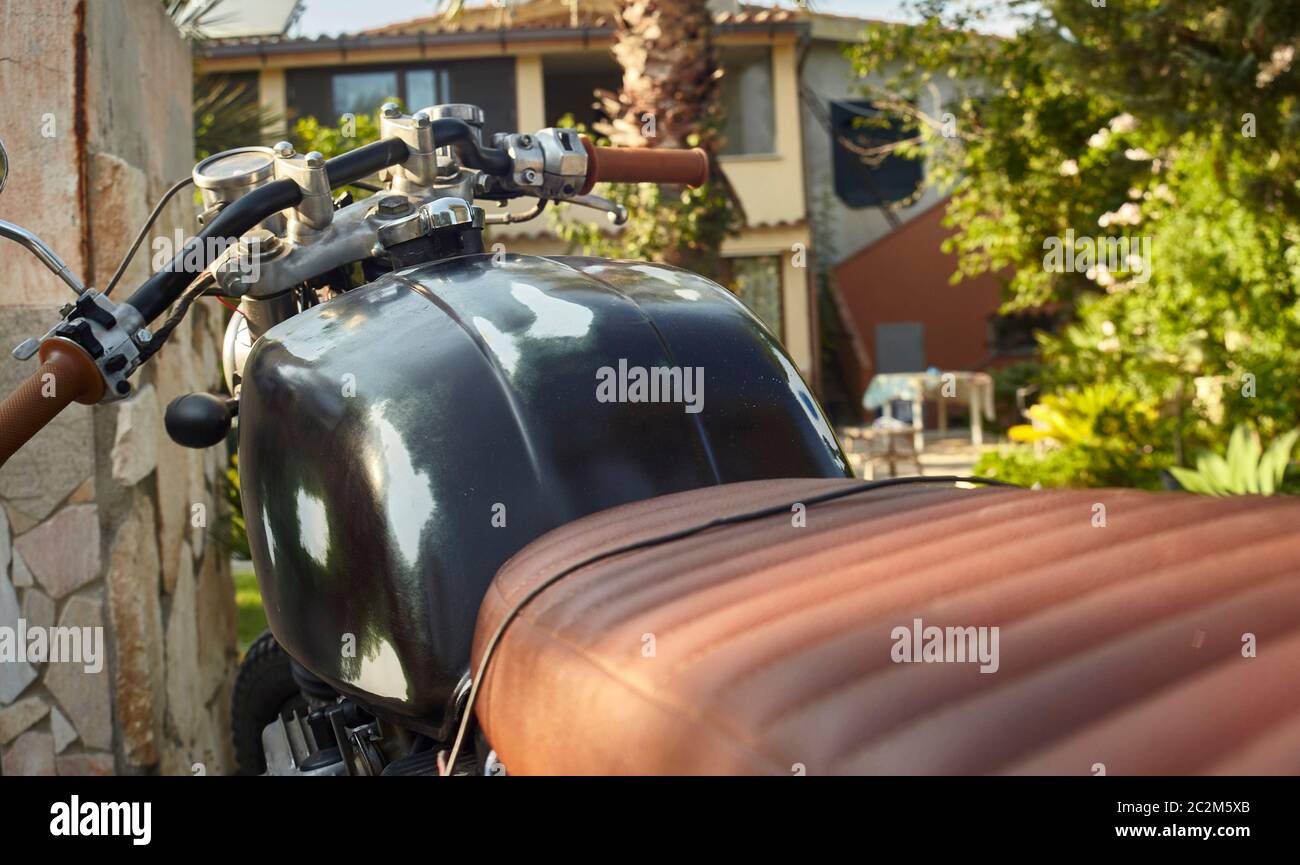 Vue de première main de la position de conduite d'une moto d'époque dépouillée et portée par le temps et de nombreux trajets. Banque D'Images