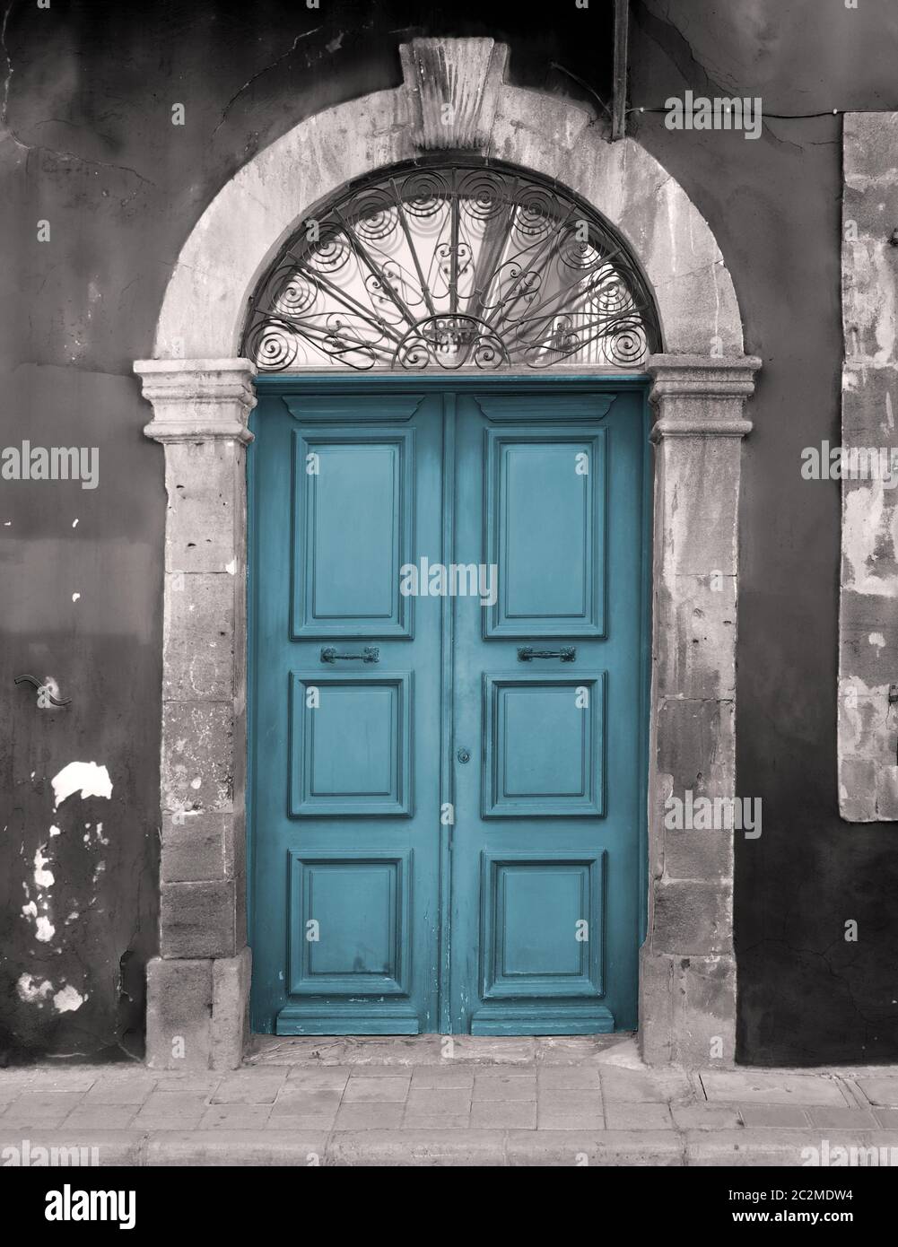 ancienne porte bleue dans un cadre en pierre voûtée avec des murs peints en écaille Banque D'Images