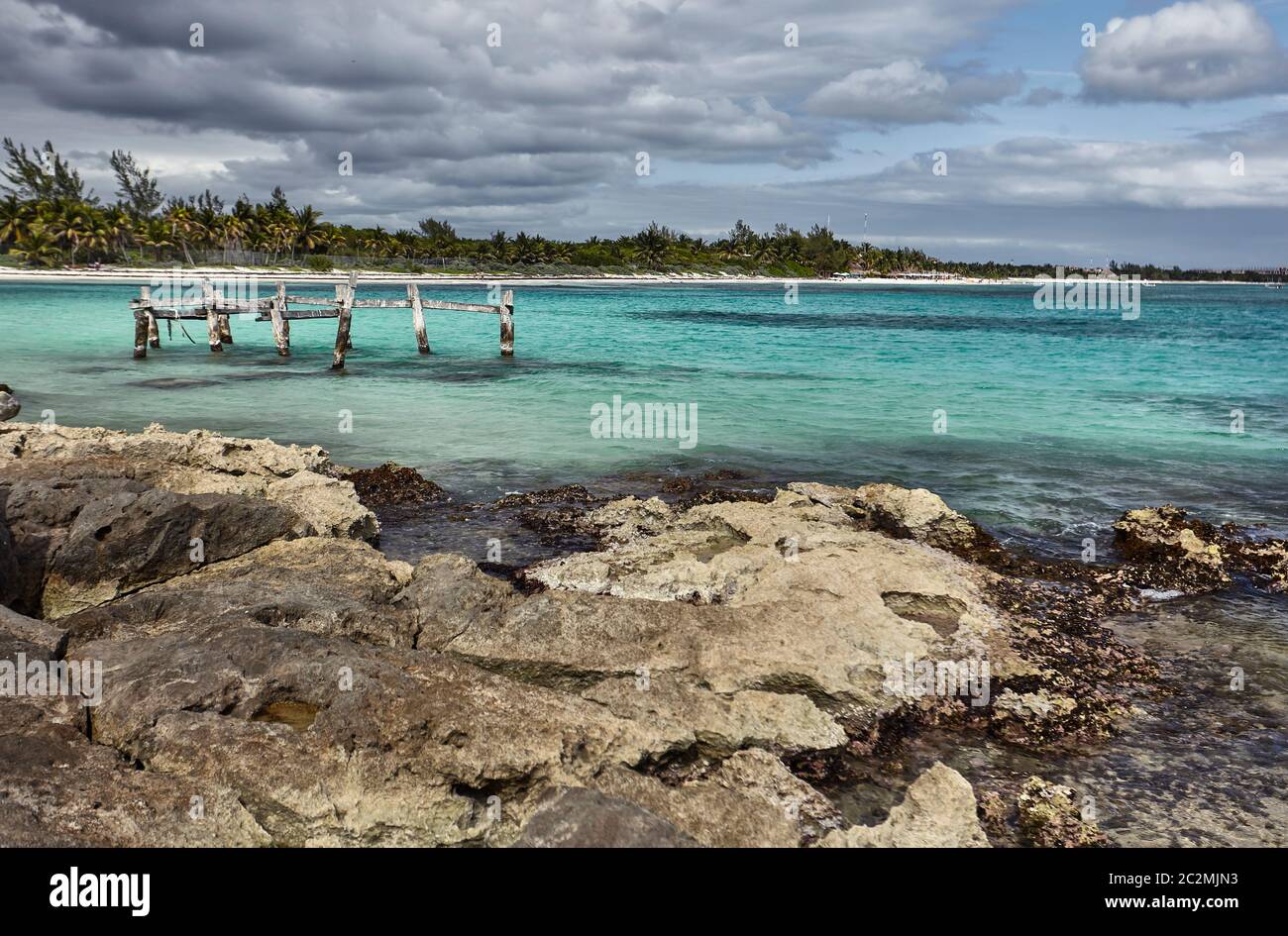 Vue sur un ancien quai en bois abandonné sur la plage de Xpu-Ha au Mexique. Banque D'Images