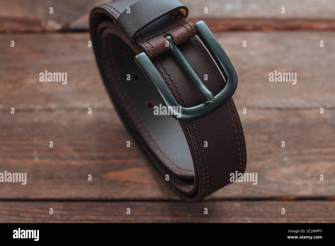 Ceinture en cuir marron foncé pour hommes avec buckley sur une planche en  bois, gros plan Photo Stock - Alamy