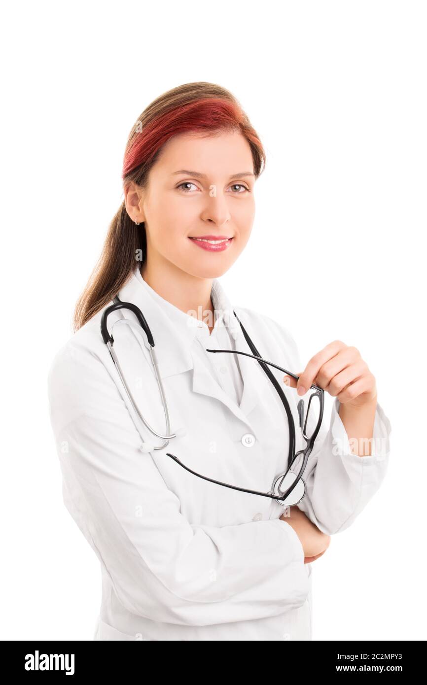 Portrait d'une jeune femme souriante, médecin ou infirmière, avec un stéthoscope autour de son cou tenant des lunettes, isolé sur le b blanc Banque D'Images