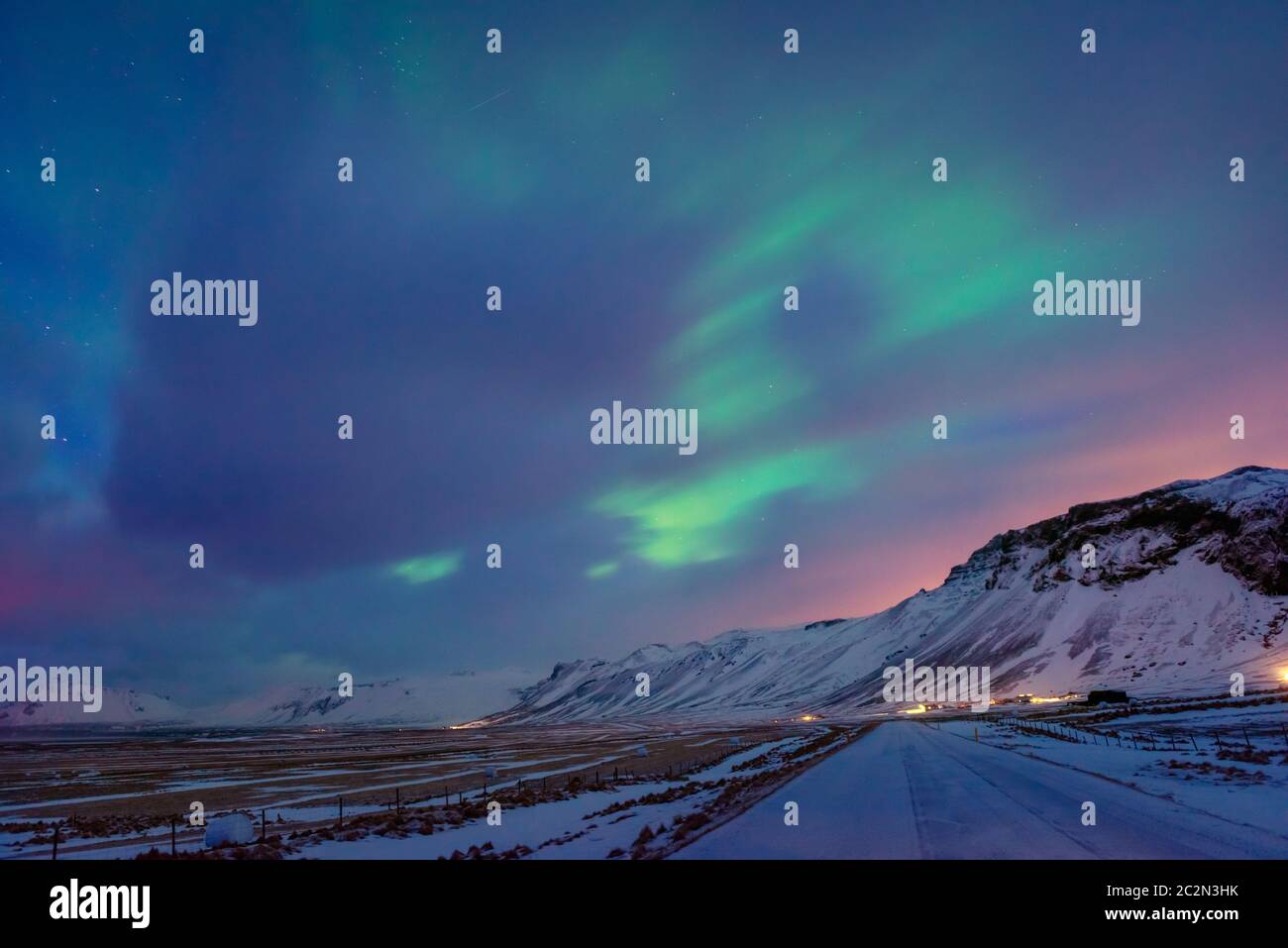 Des lumières du Nord étonnantes, une vue magnifique sur un ciel coloré au-dessus des hautes montagnes couvertes de neige, une merveilleuse nature de l'Islande Banque D'Images