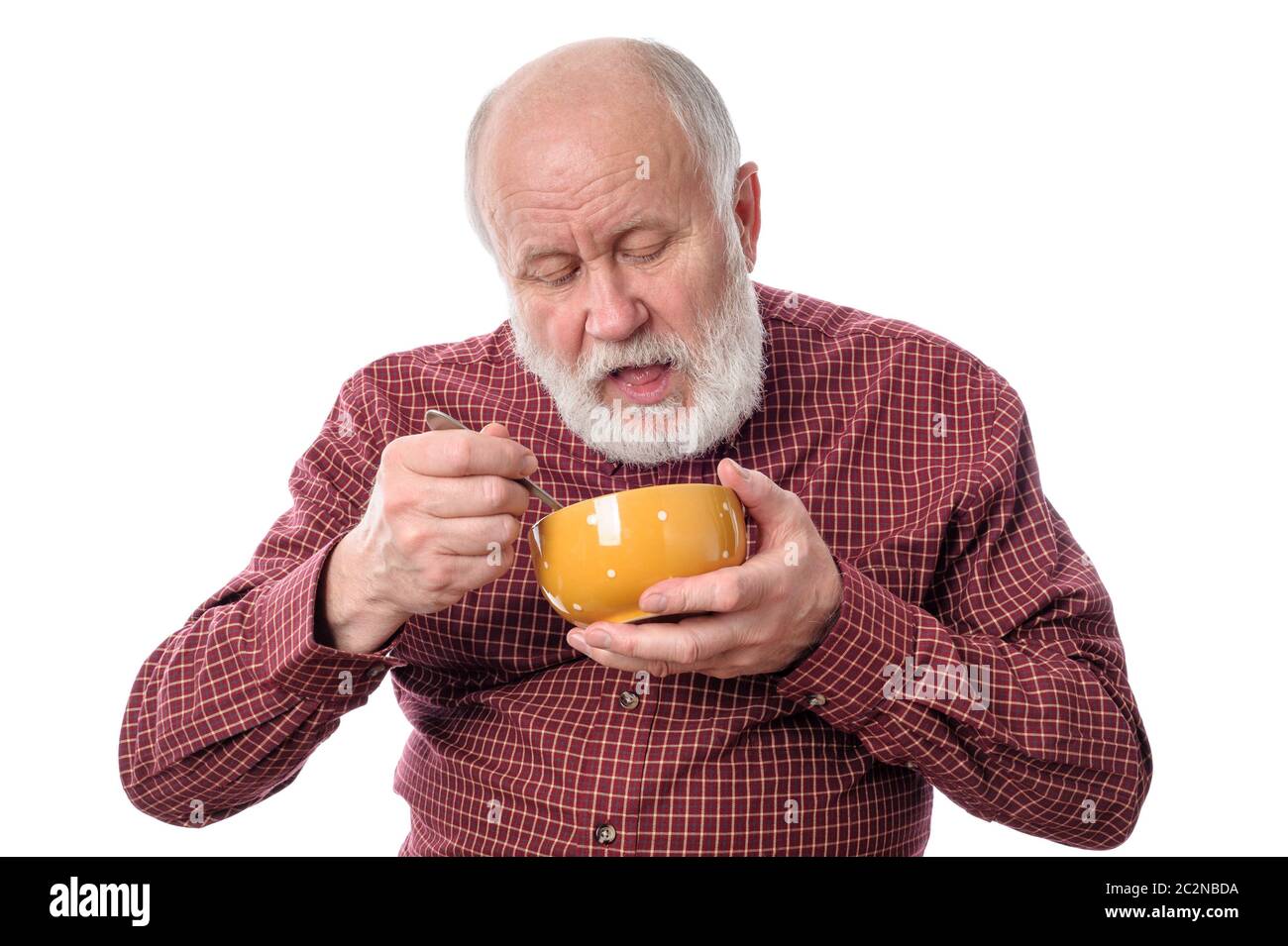 Homme senior mangeant de l'oragne bol , isolé sur blanc Banque D'Images