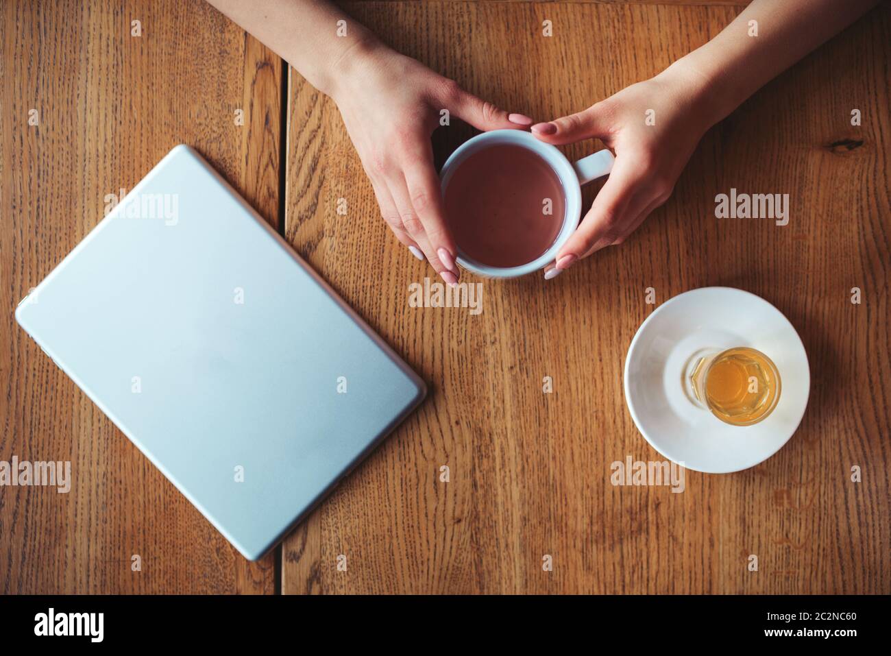 Female hands holding cup Vue de dessus sur fond de bois. Banque D'Images