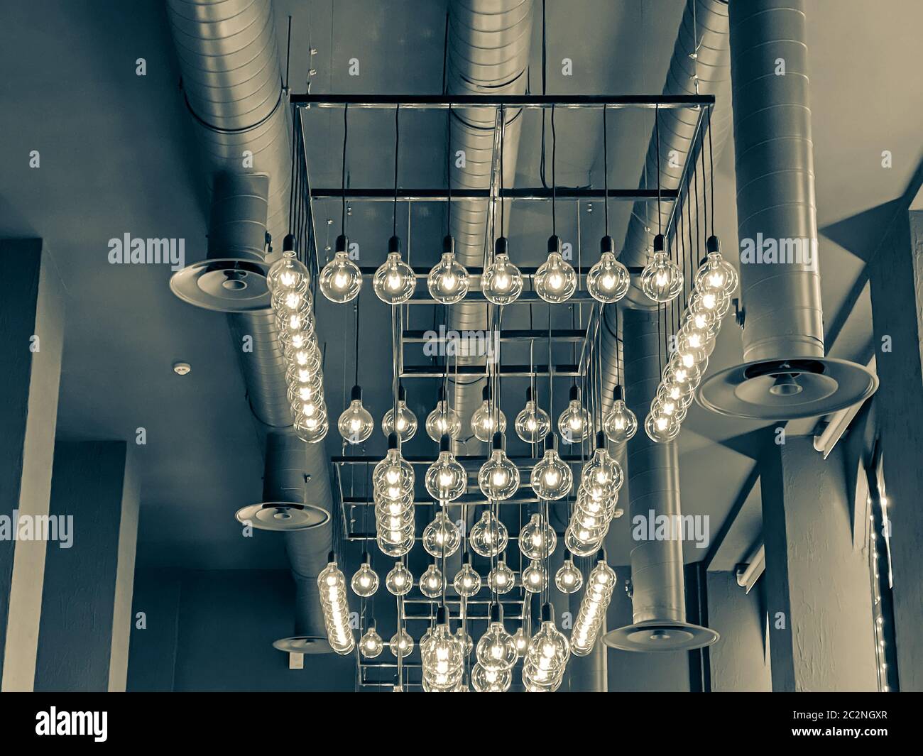 design moderne du plafond du restaurant avec lampes à incandescence. beaucoup de lampes rétro suspendues dans l'intérieur du café. image tonifiée Banque D'Images
