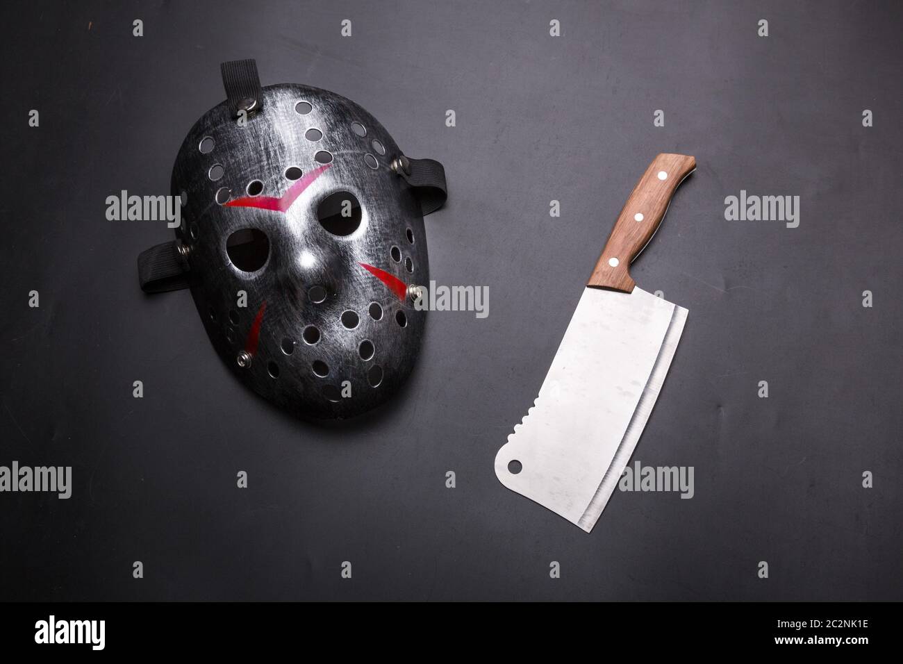 Psycho fou instruments homme isolé sur fond noir. Masque de hockey avec bandes sanglante et la viande cleaver. Outils de meurtrier en série Banque D'Images