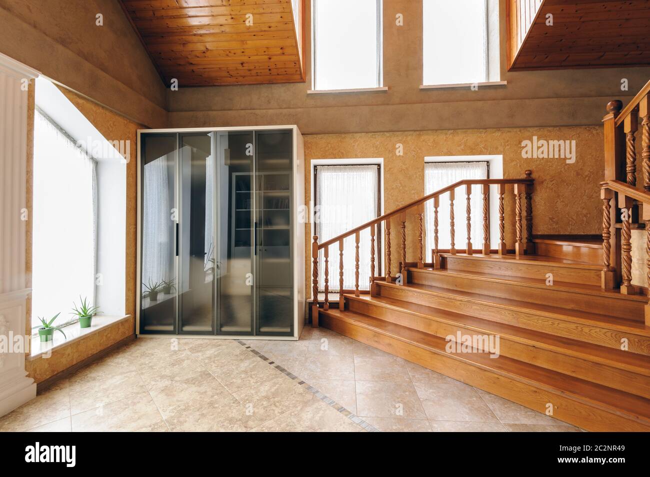 Grand hall d'entrée d'une maison moderne avec des escaliers en bois Banque D'Images