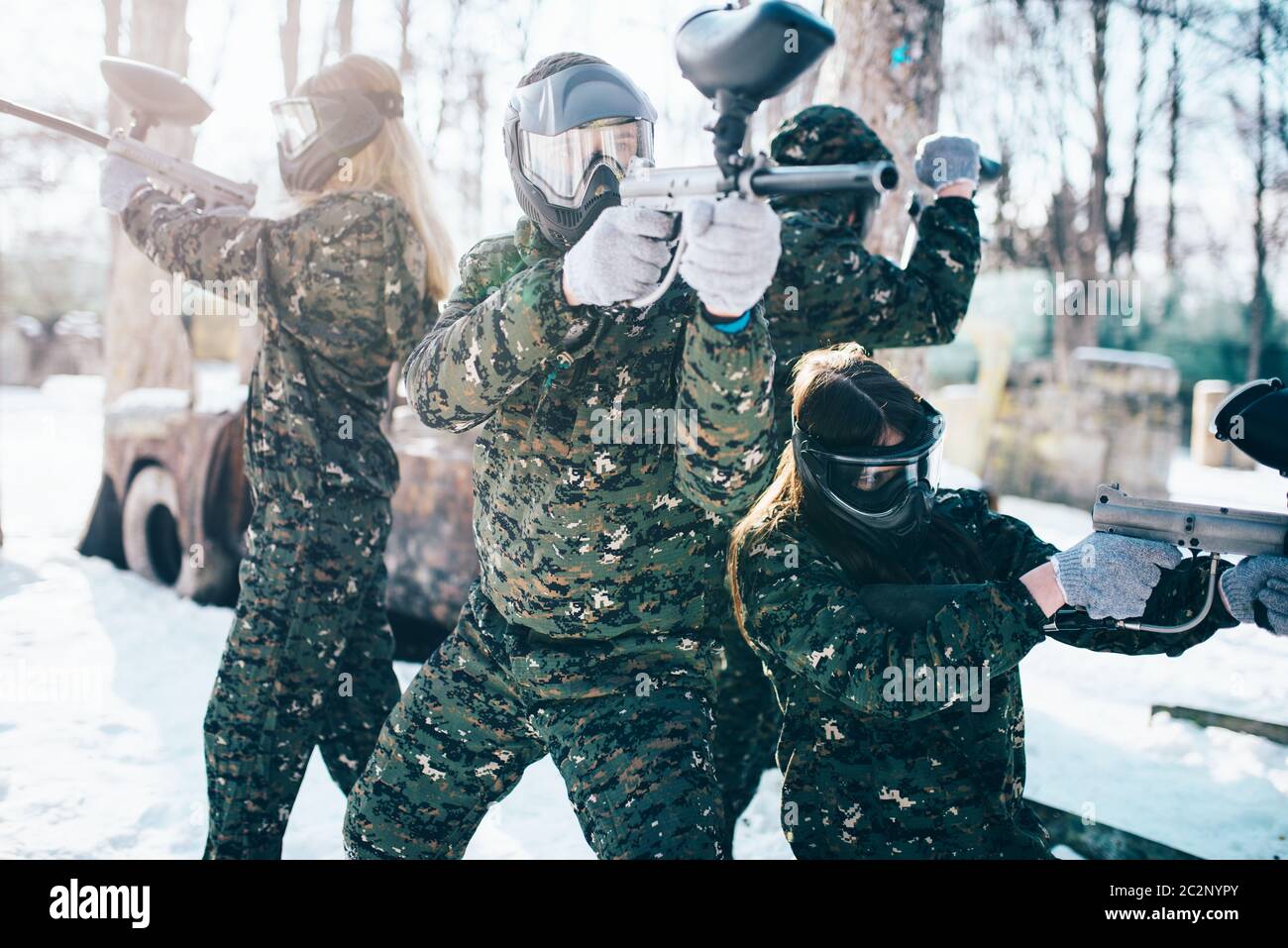 Les joueurs de paintball en uniforme et des masques pose avec des armes