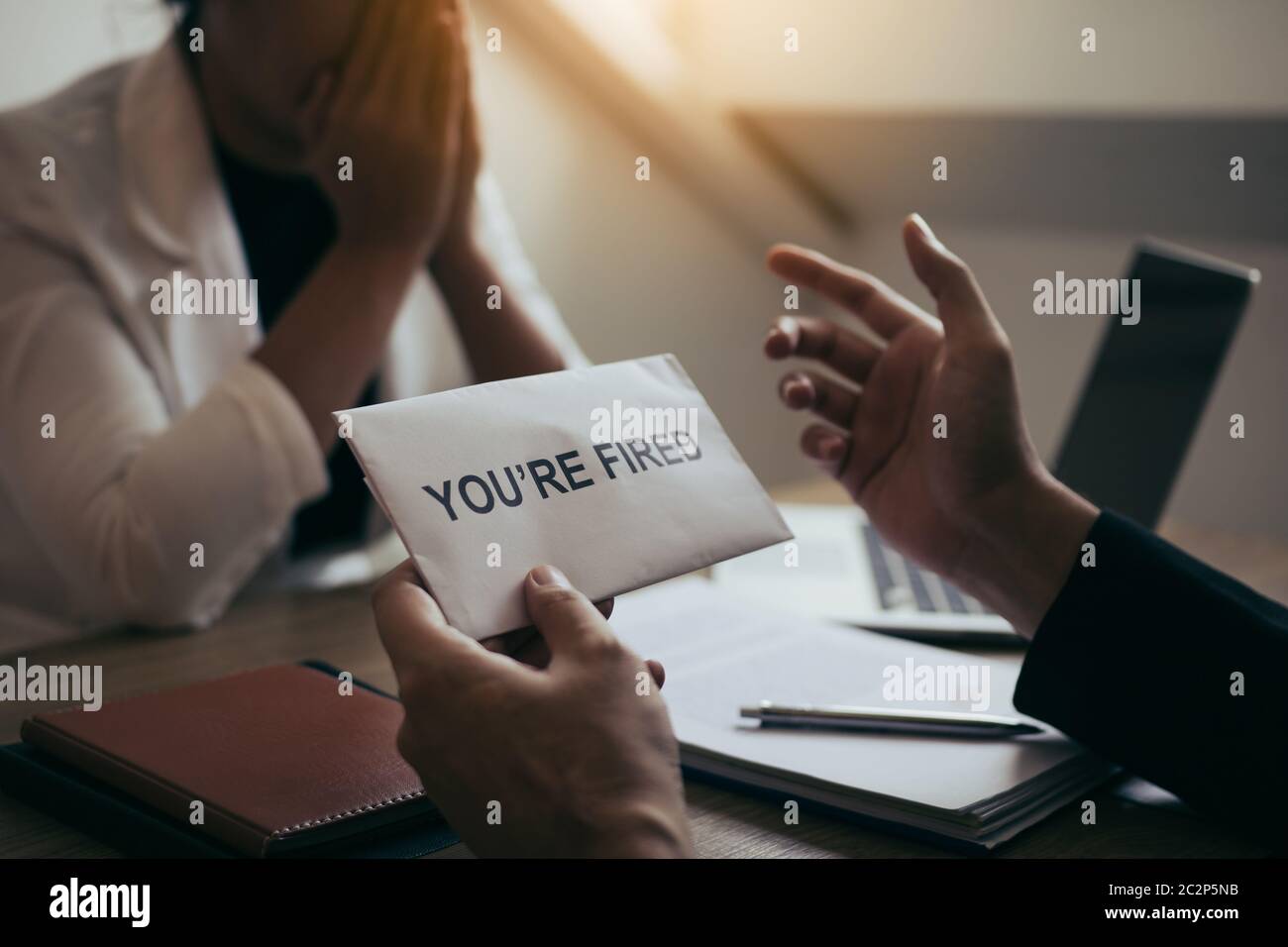 Le Manager masculin parle ou explique qu'il faut licencier l'employé tout en lui donnant une enveloppe de démission. Banque D'Images