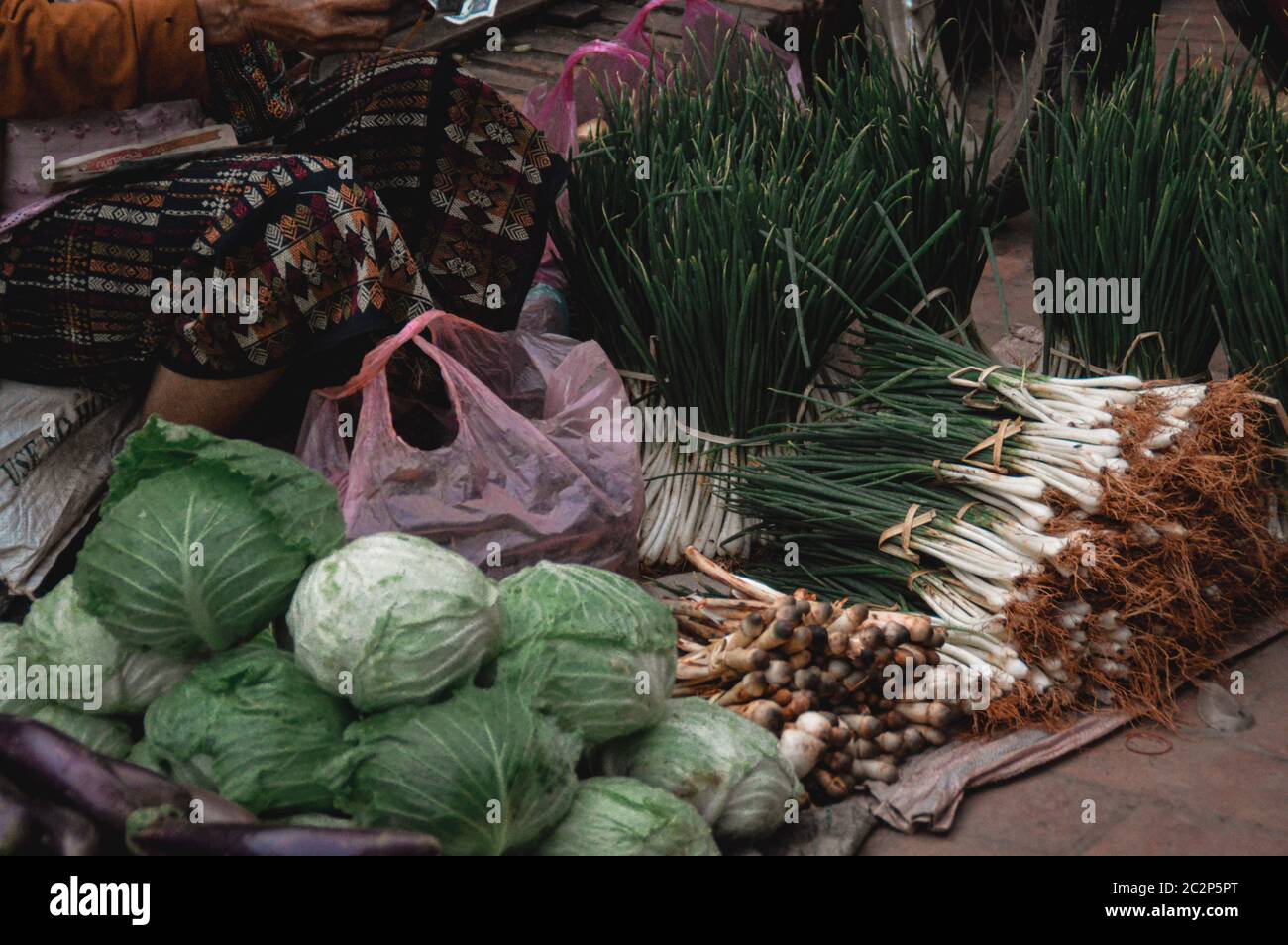Vendeur vendant des légumes à Luang Prabang marché matinal au Laos qui montre la vie, la culture et les moyens de subsistance de la population locale Banque D'Images