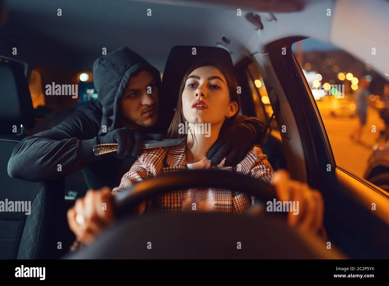 Une Femme Et Un Cambrioleur De Voiture à Capuchon Avec Couteau Sur Le