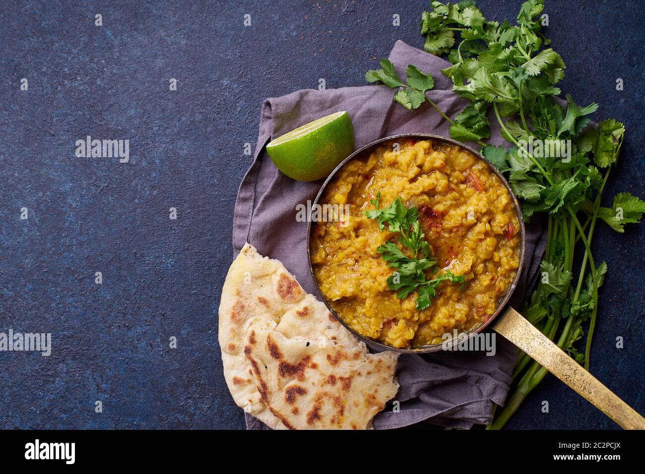 Soupe de curry de lentilles rouges indiennes dal avec riz naan. Plat indien végétalien sur fond de béton avec espace de copie Banque D'Images