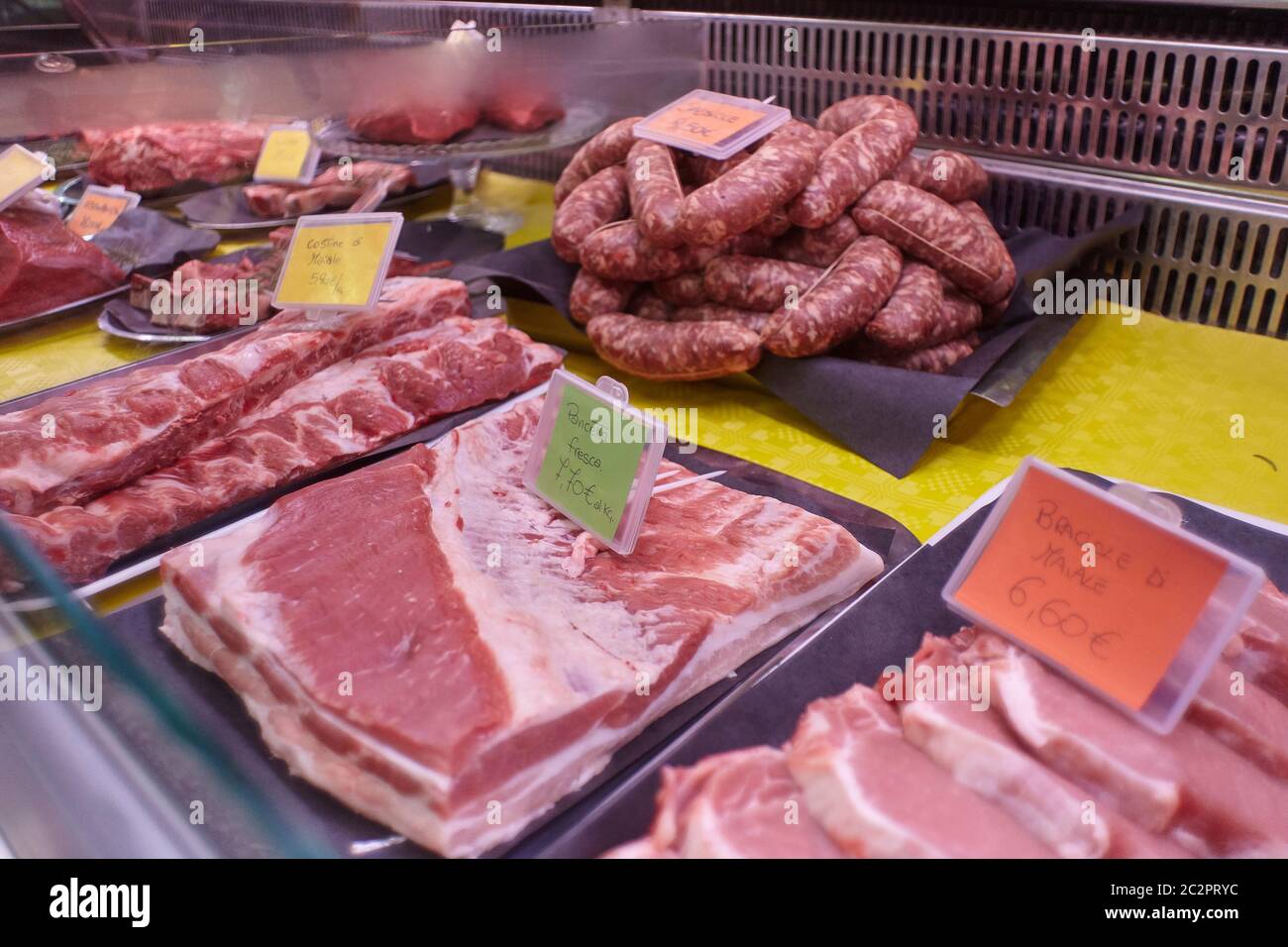 Coupes de viande de veau crues dans un comptoir froid avec étiquettes de prix prêtes à être vendues dans la boutique du boucher. Banque D'Images