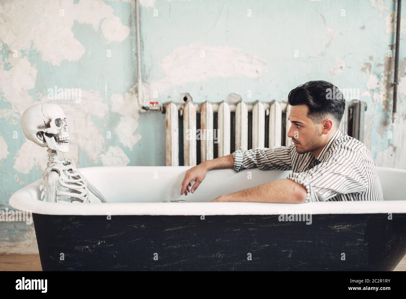 Homme d'affaires en faillite assis dans la baignoire contre le squelette  humain, suicide homme concept. Problème dans les affaires, dépression Photo  Stock - Alamy