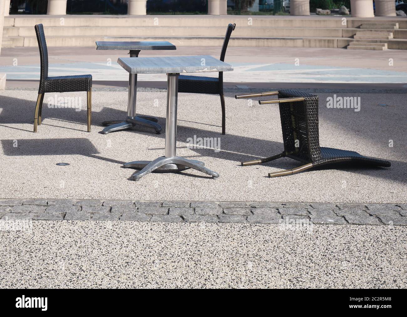Terrasse d'un bar vide avec une chaise tombée Banque D'Images